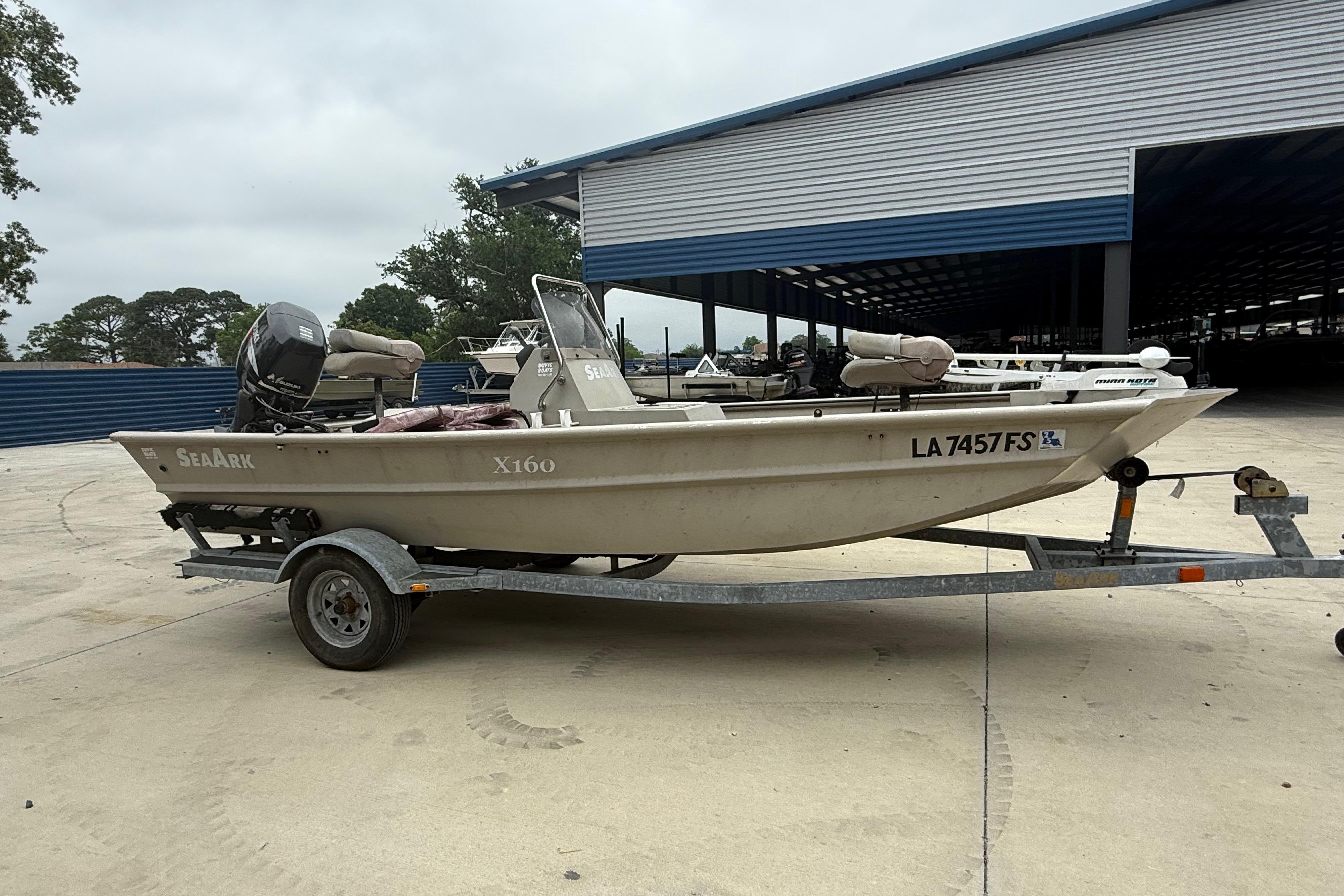2008 SeaArk 1652 MV boat on trailer, parked outdoors near a storage facility.