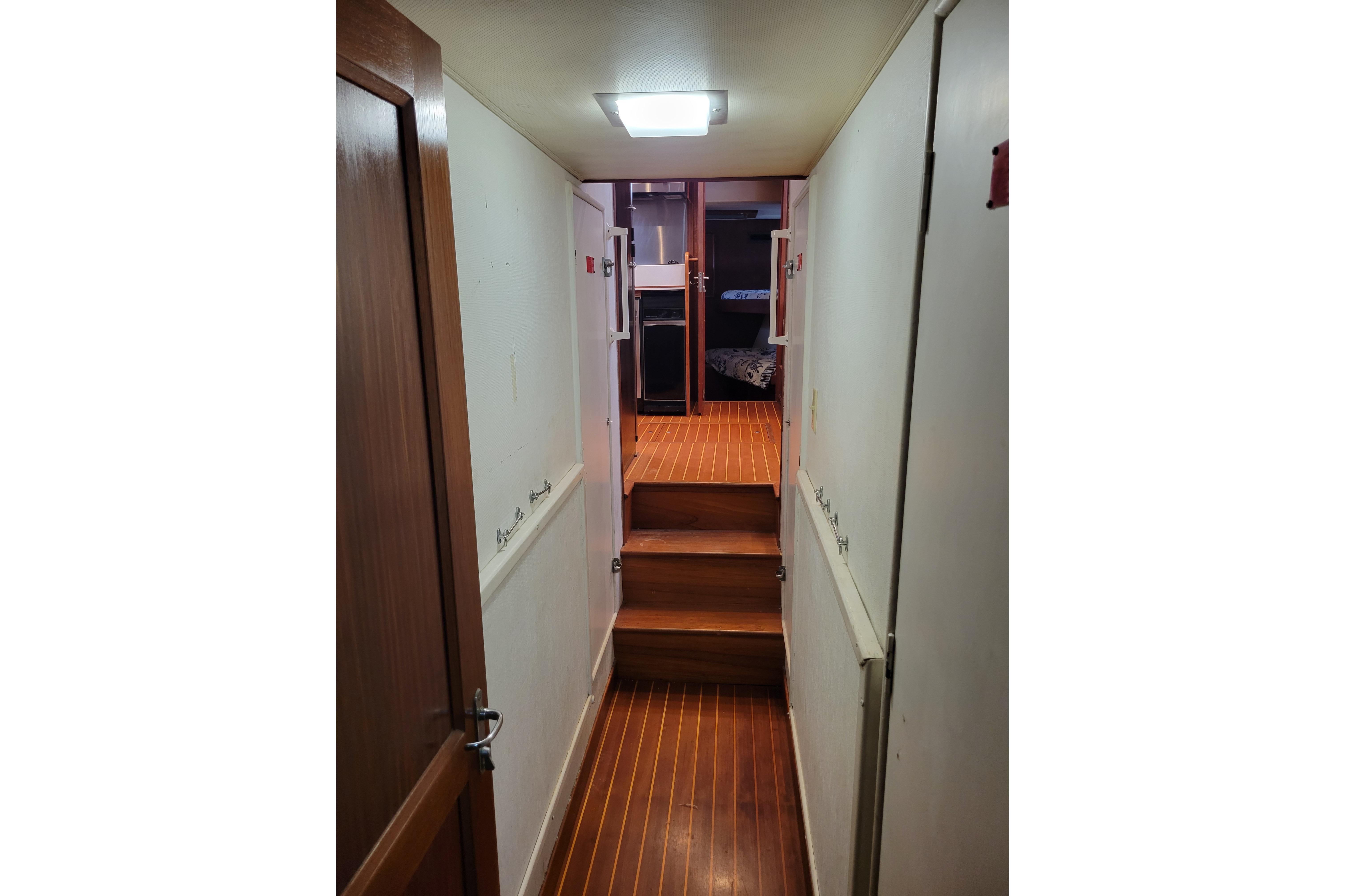 Interior hallway of 1980 Hatteras 53 Yacht Fisherman with wooden flooring and doors.