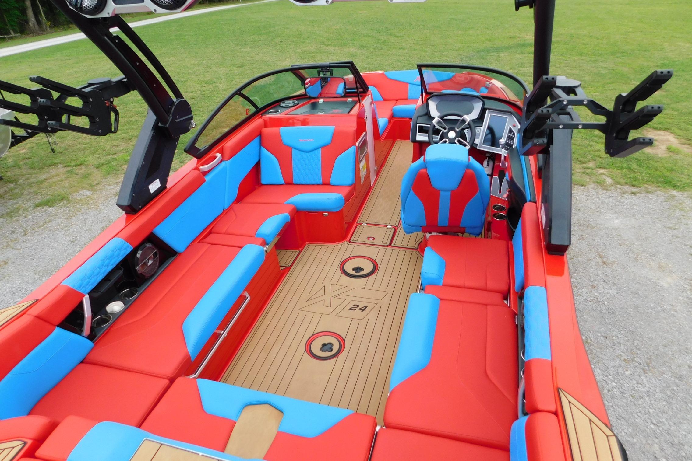 2022 MasterCraft NXT24 boat interior with vibrant red and blue seating, modern dashboard.