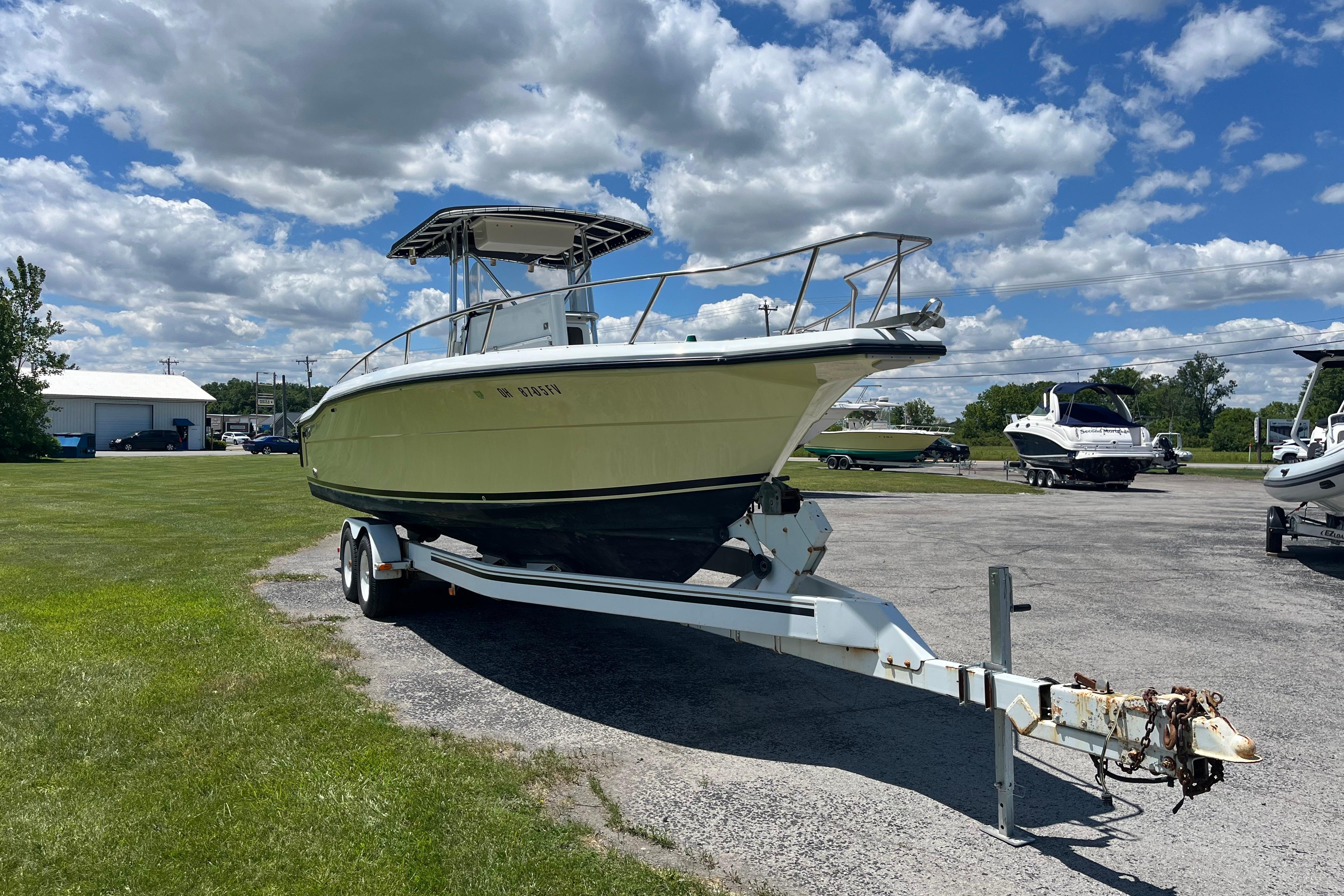 1997 Stamas boat on trailer under a partly cloudy sky in a parking area.