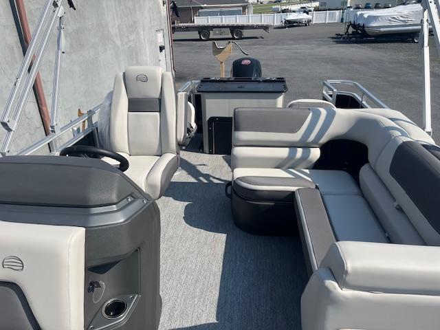 2026 Sun Tracker Fishin' Barge 20 DLX interior with seating and steering console.