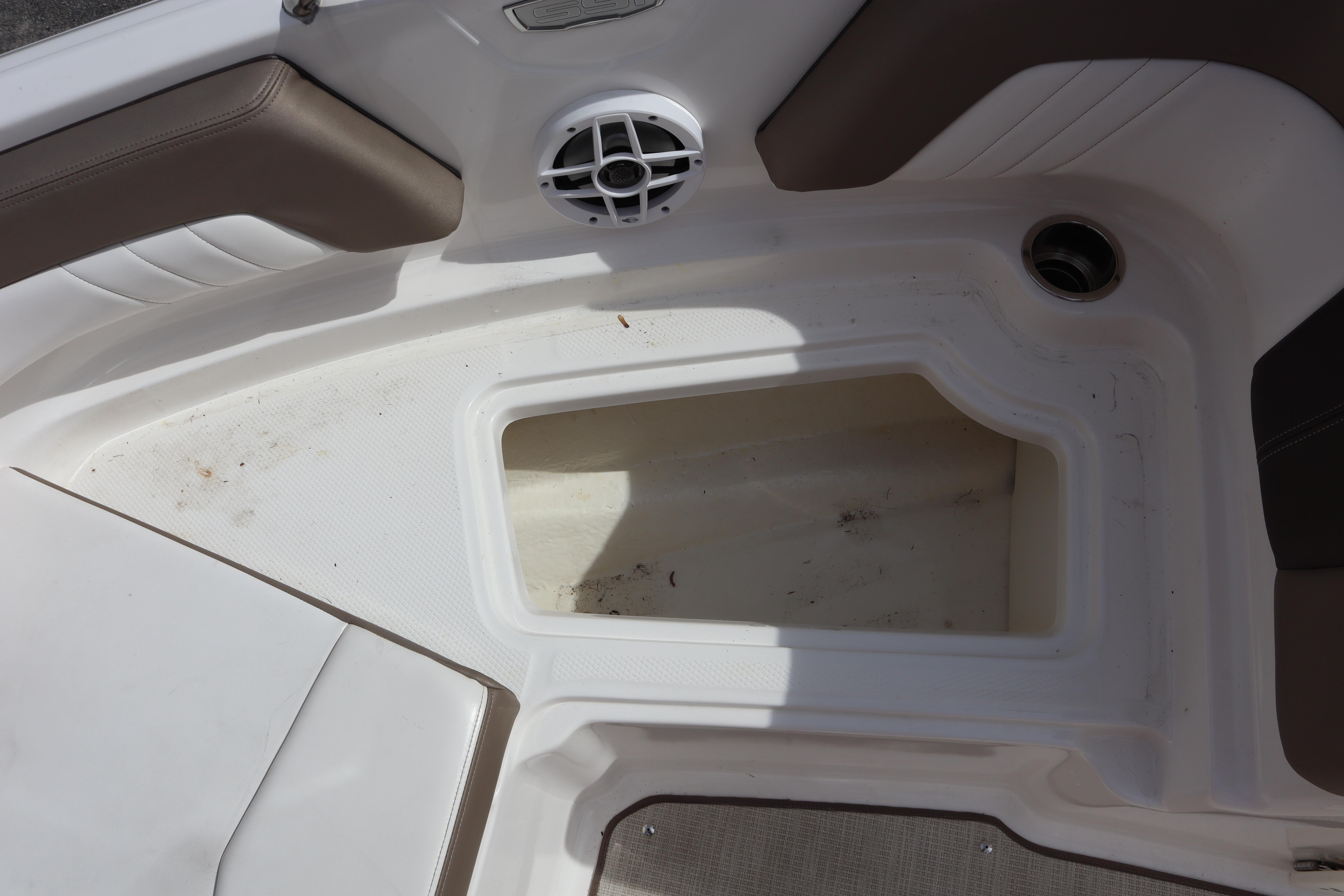 Interior storage compartment of a 2021 Chaparral 21 SSi boat with speaker and cup holder.