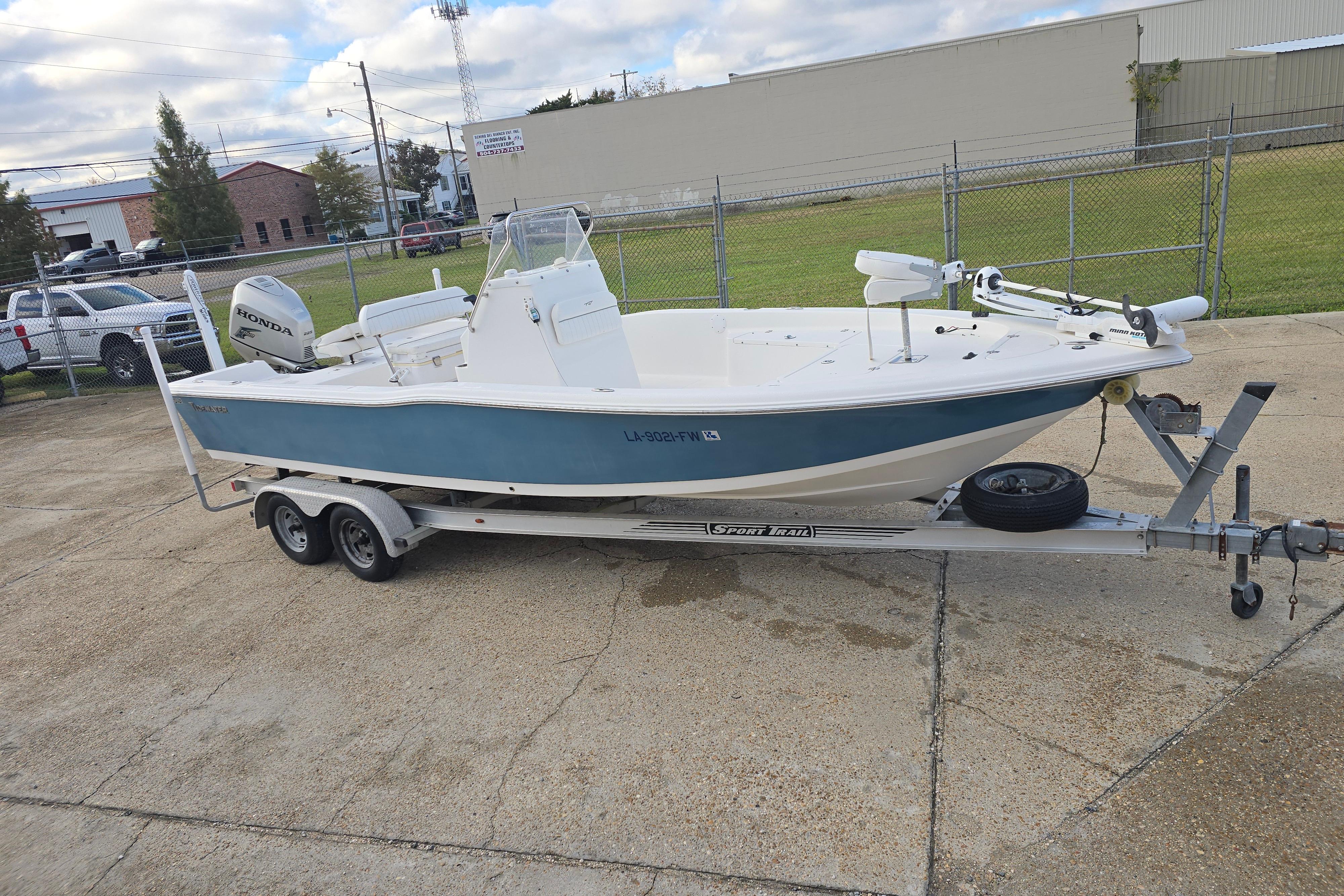 2011 Tidewater 2400 Bay Max boat on trailer, parked outdoors.