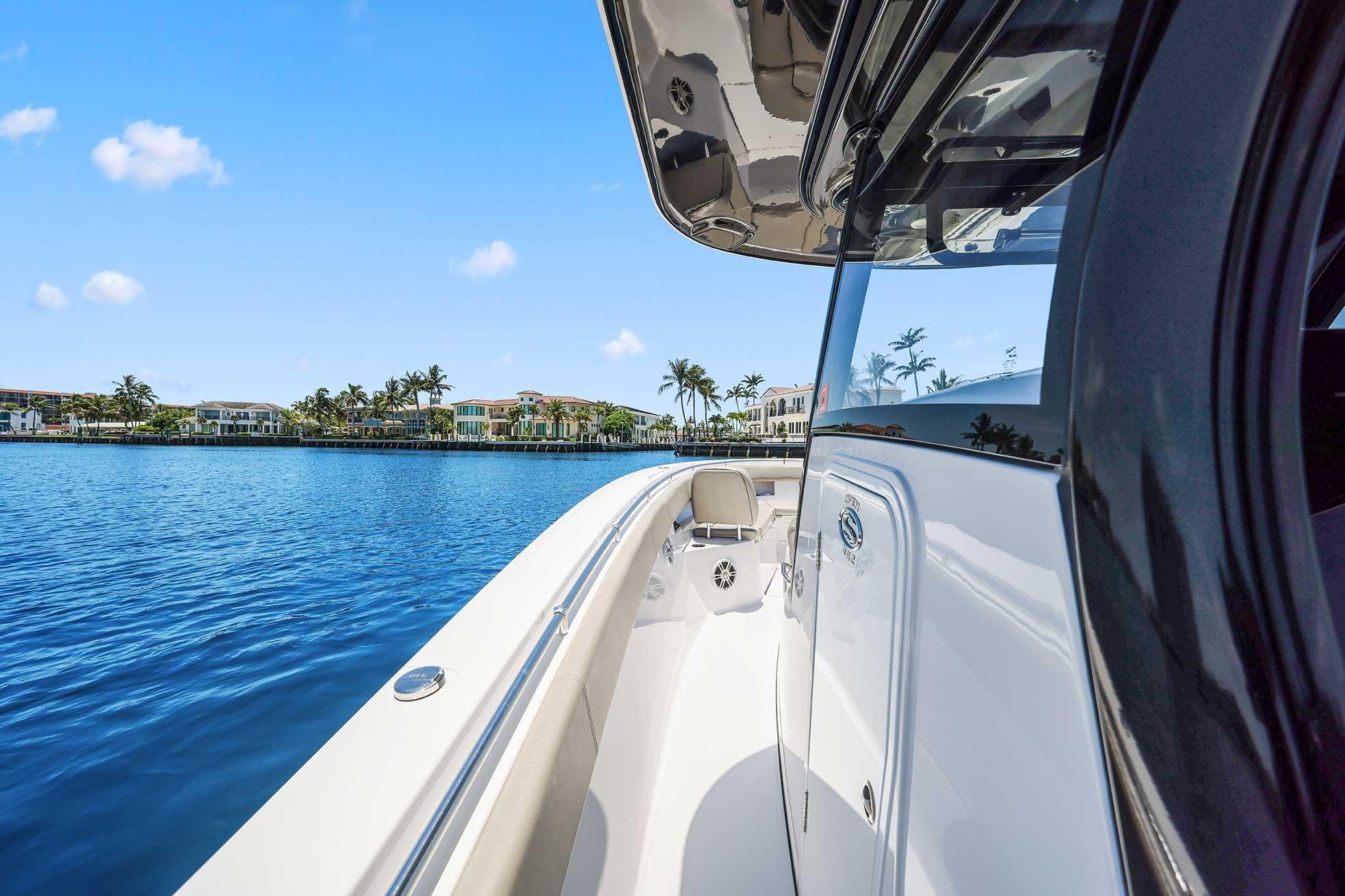 2024 Sportsman Open 352 Center Console boat on serene water with luxury homes in background.