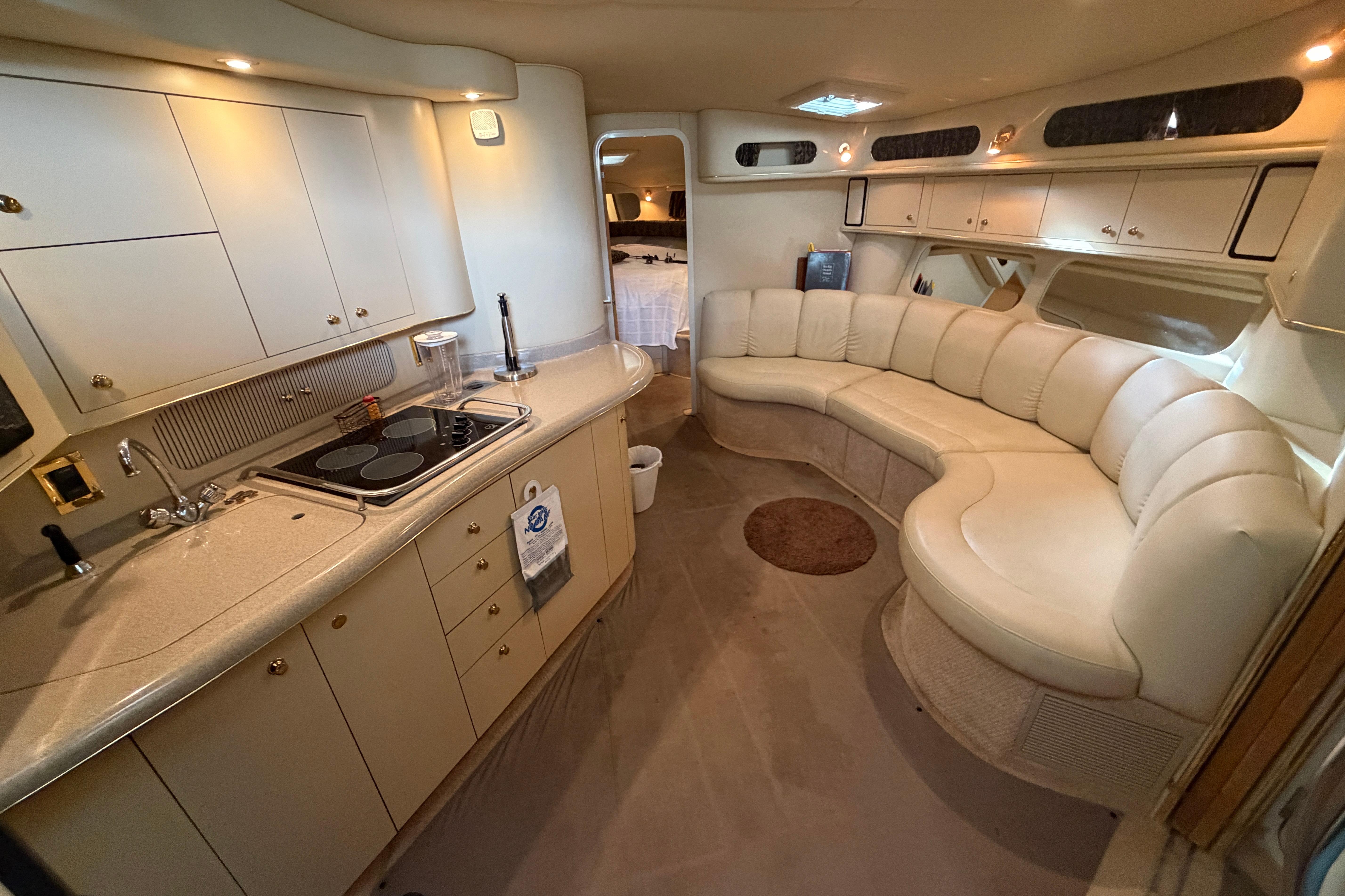 Luxurious interior of a 1999 Sea Ray 400 Sundancer yacht with kitchen and seating area.