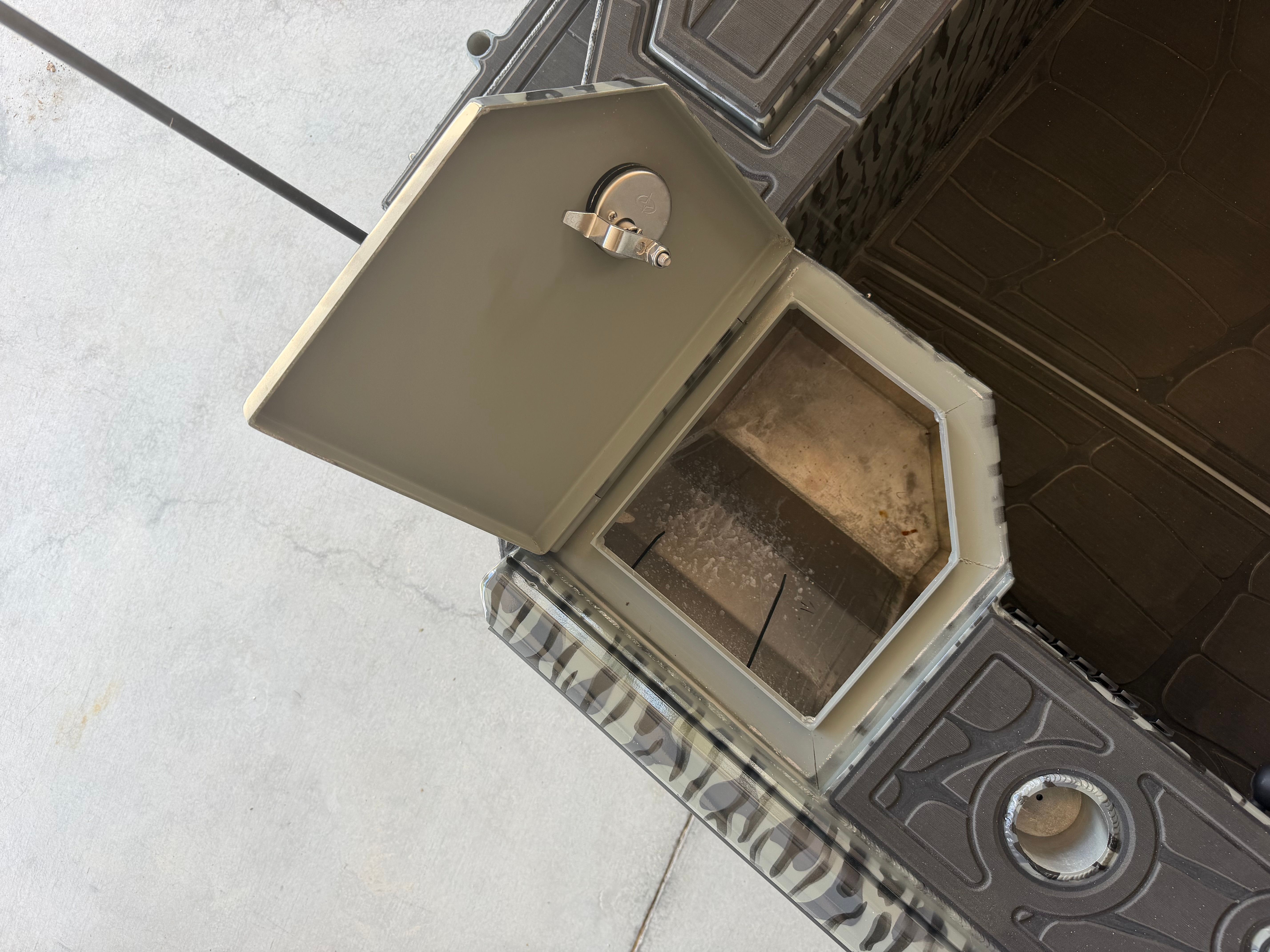 An open compartment on a boat with a metal latch.