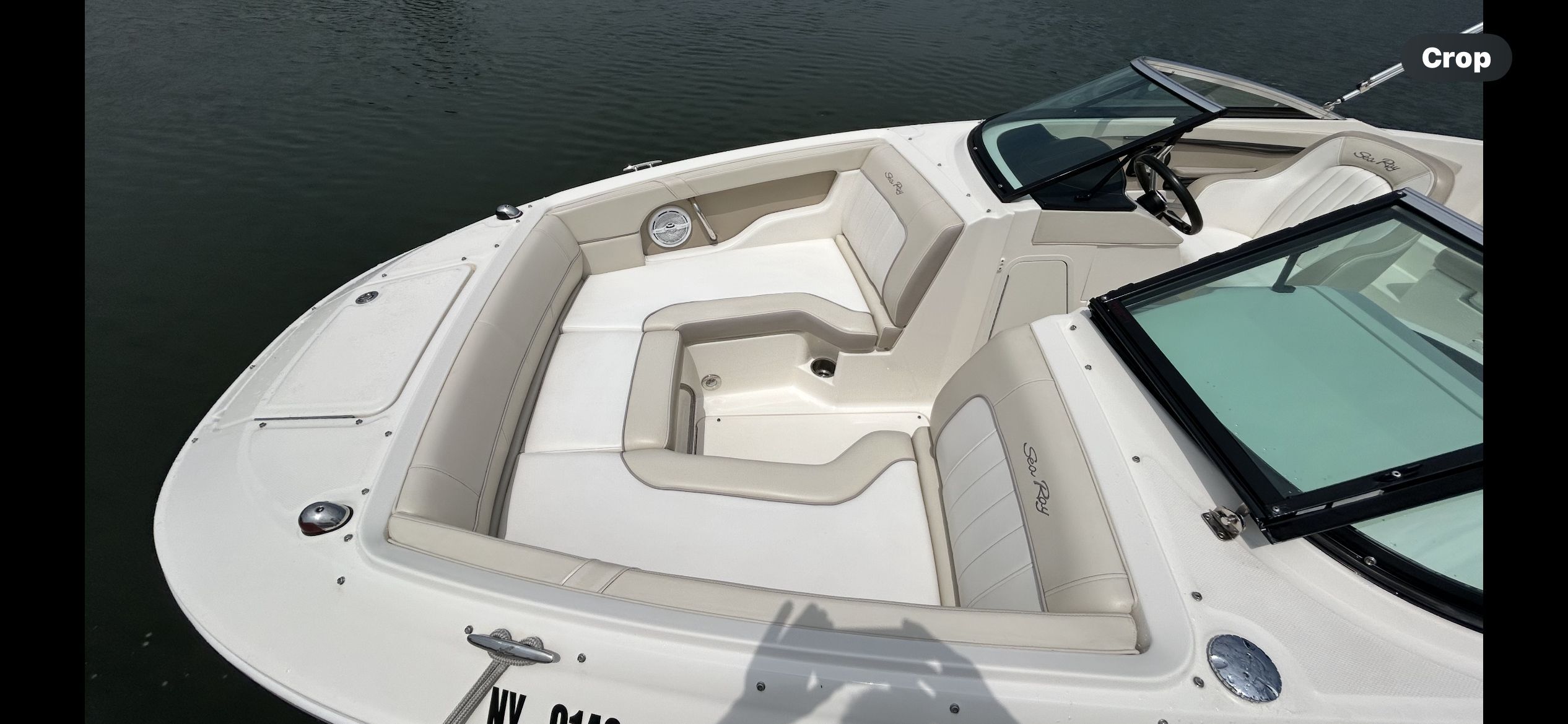 A 2013 Sea Ray 220 Sundeck with beige upholstery and a black windshield frame.