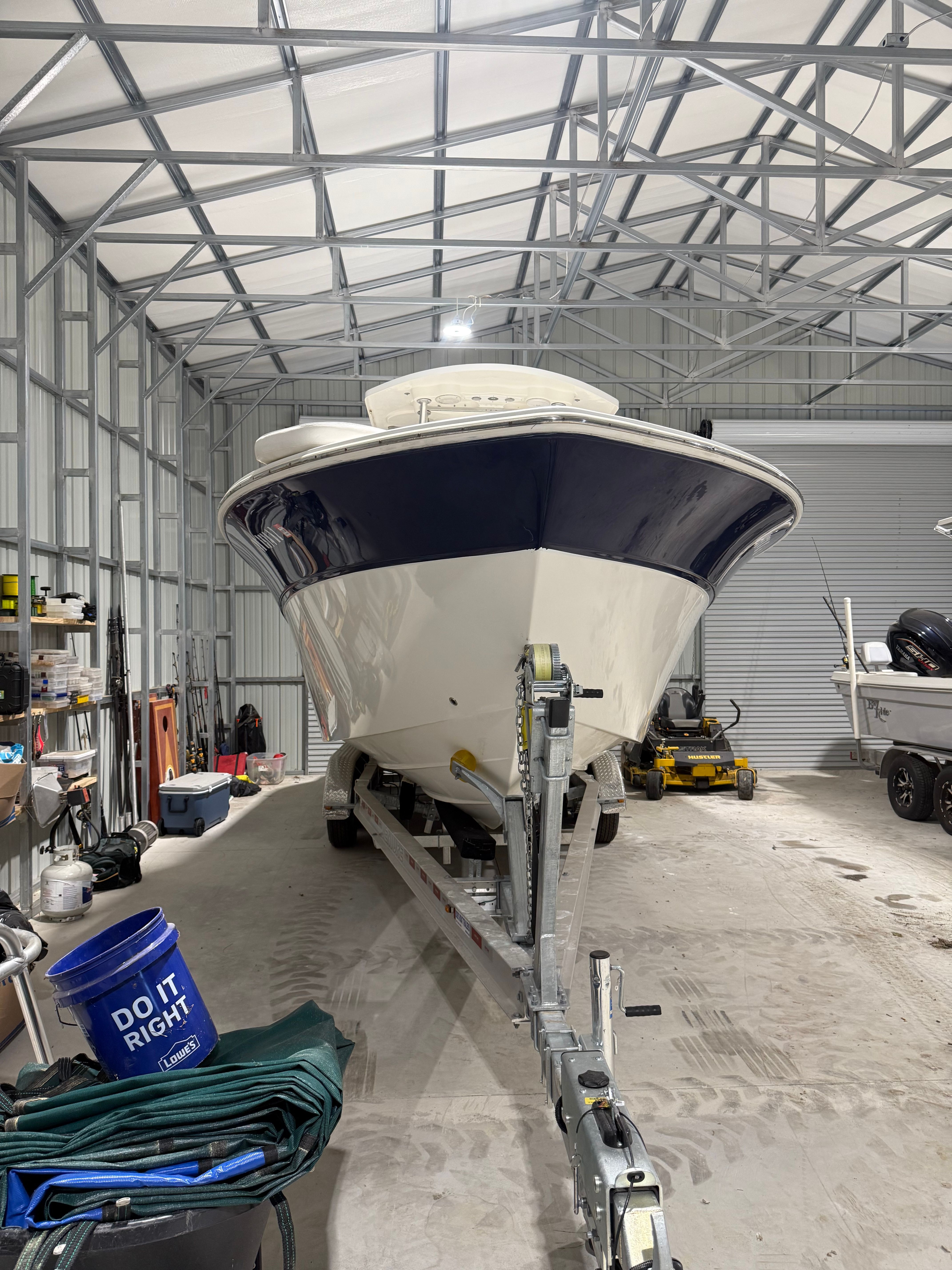 A 2012 Sea Fox 286 Center Console boat is on a trailer in a covered storage area.
