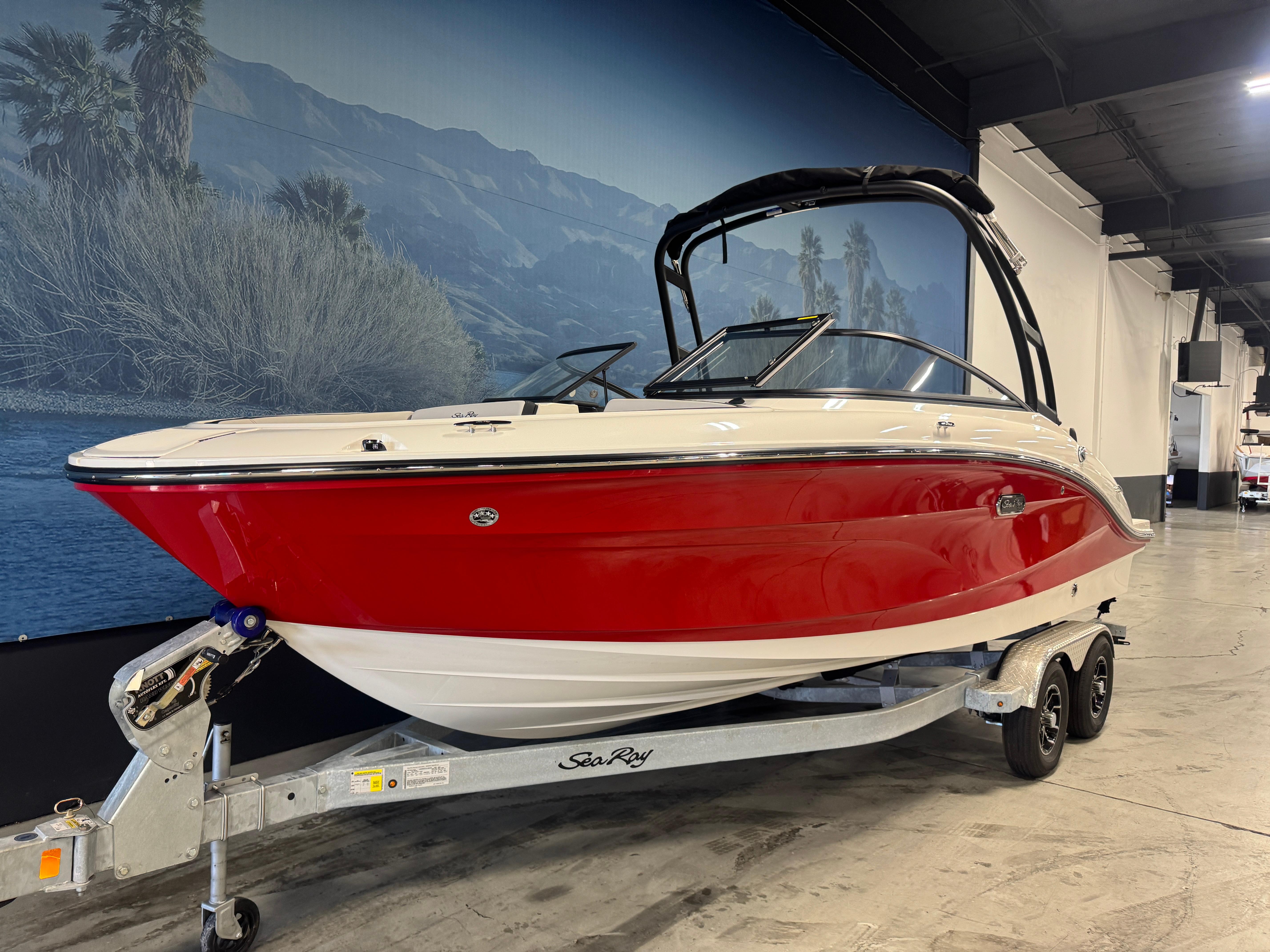 2026 Sea Ray SPX 210 boat with red hull on trailer in showroom.