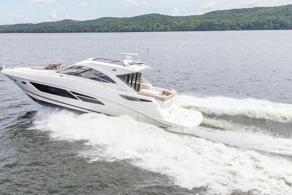 2016 Sea Ray Sundancer 510 cruising on a lake with scenic forested hills.