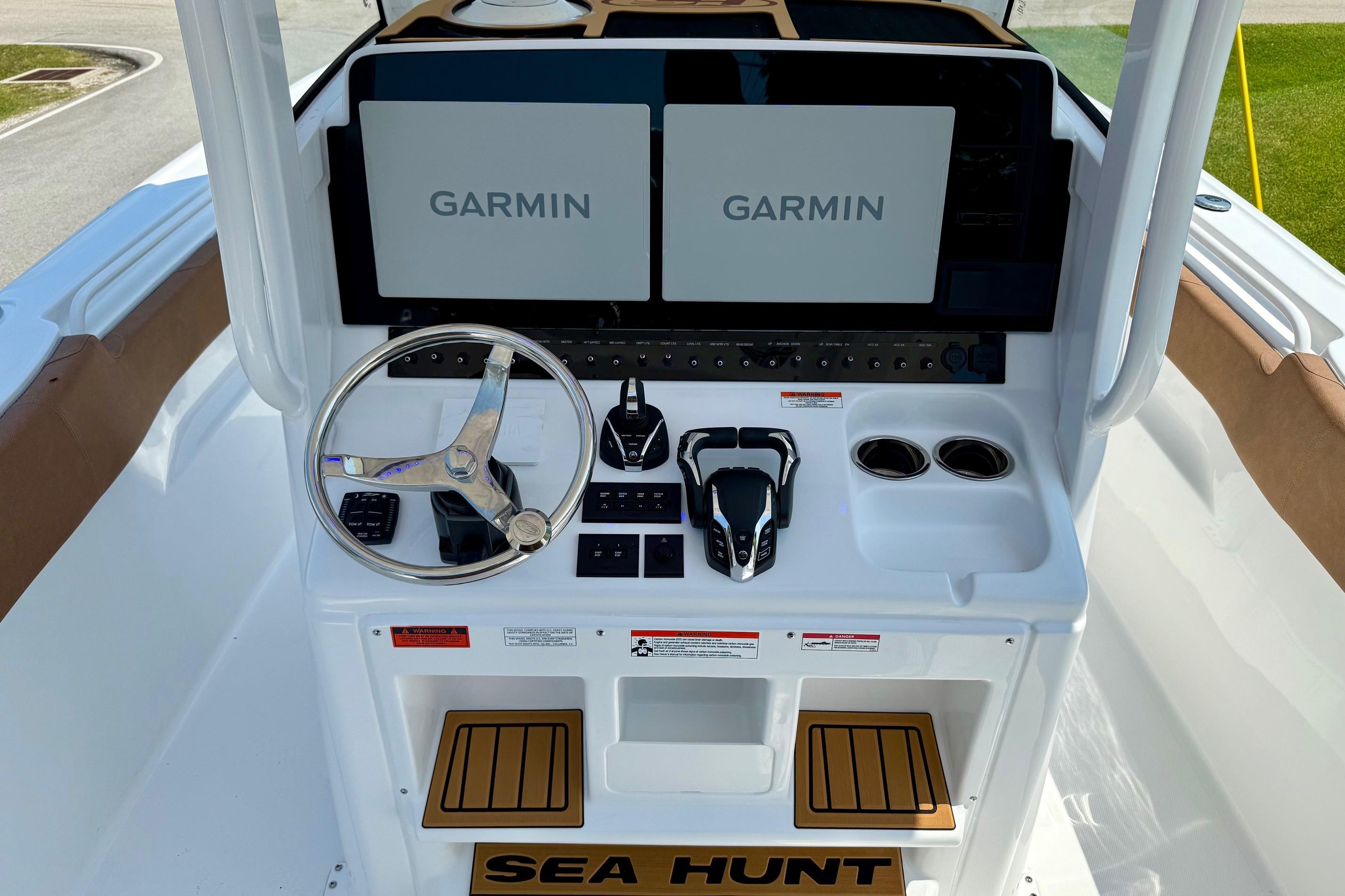 2026 Sea Hunt Ultra 305 SE boat dashboard with dual Garmin displays and steering wheel.