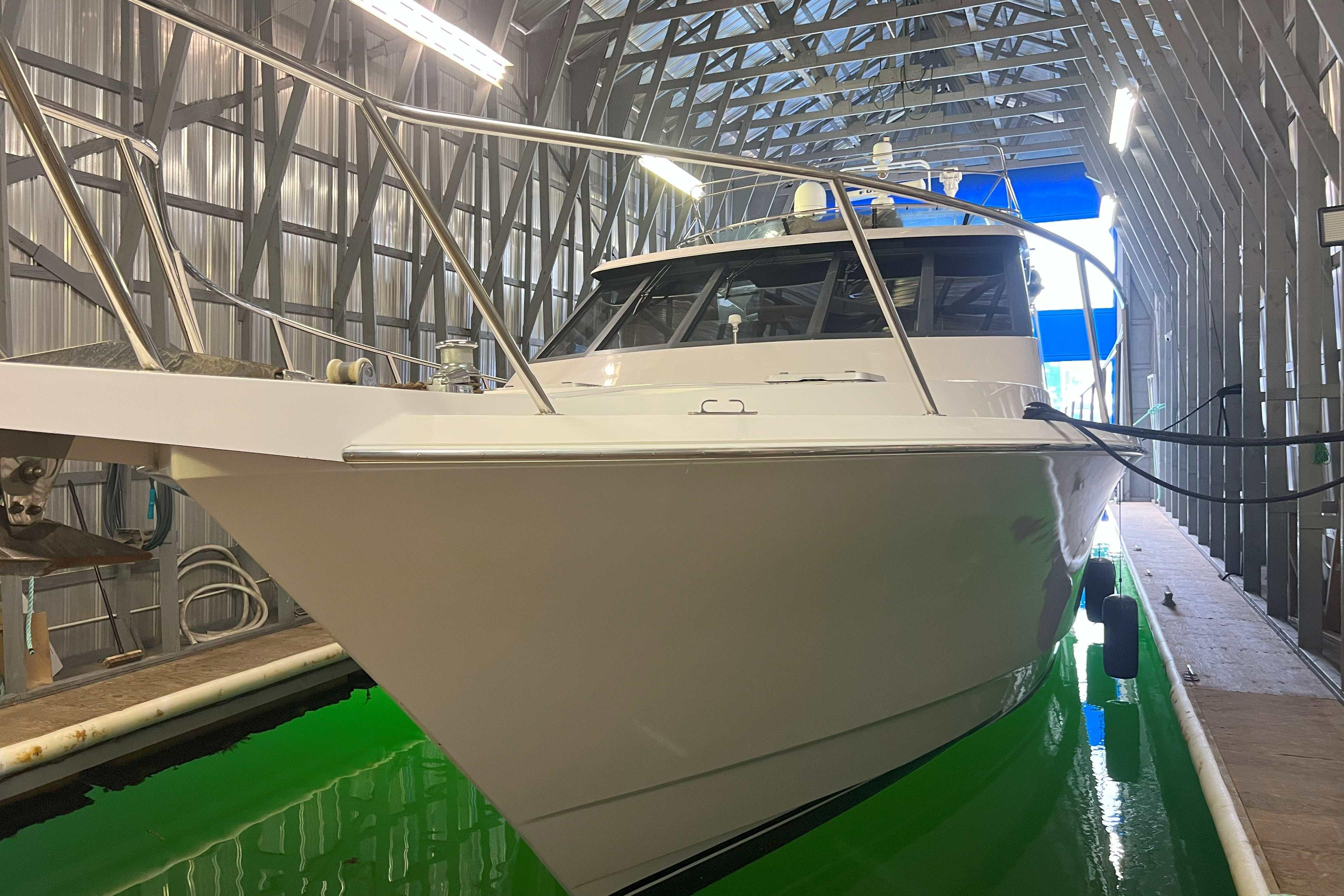 1998 West Bay 58 yacht in a metal boathouse with green water.