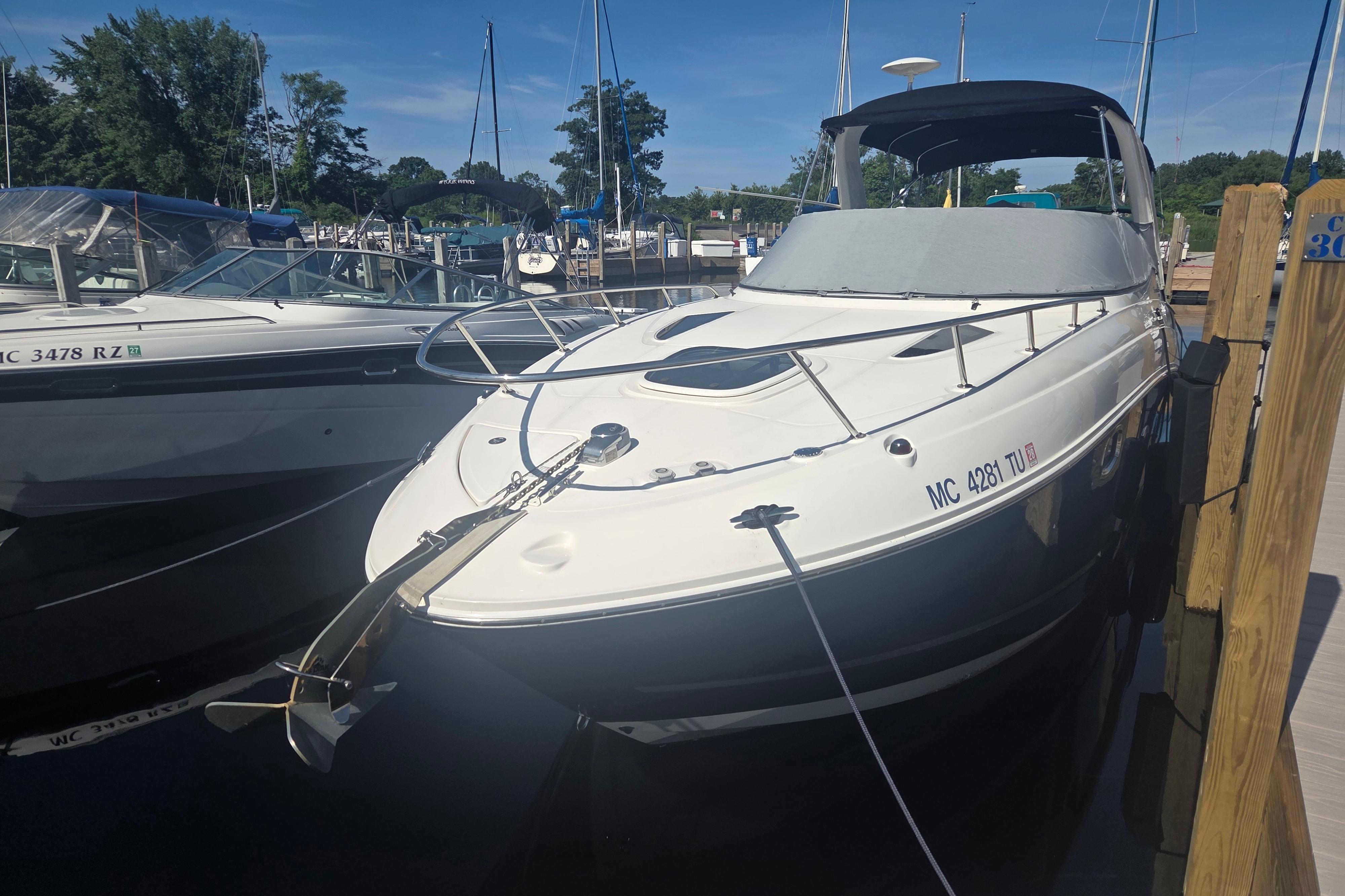 2012 Sea Ray Sundancer 260 docked at marina under clear blue sky.