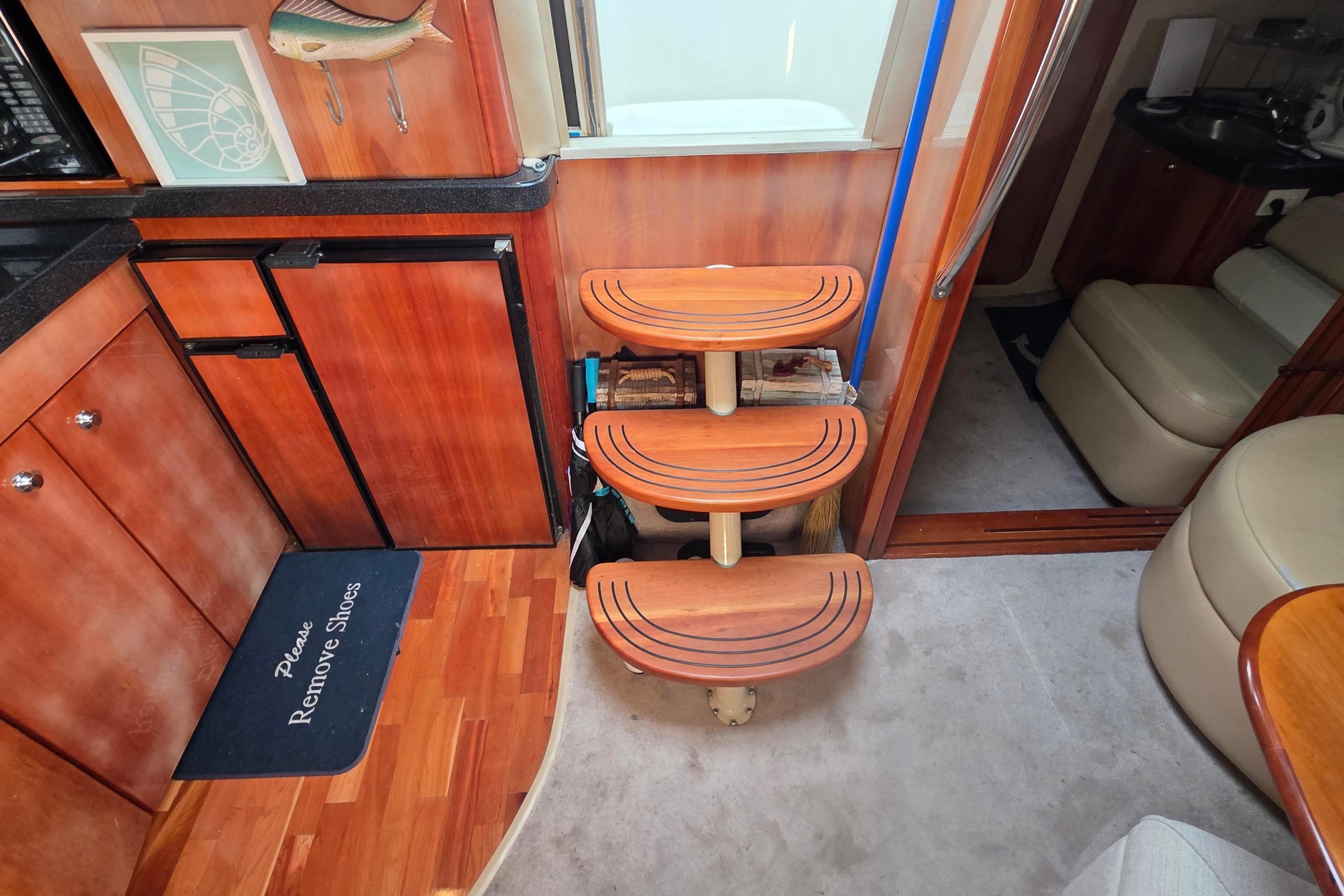 Interior of 2002 Regal Commodore 4260 yacht with wooden steps and kitchen area.