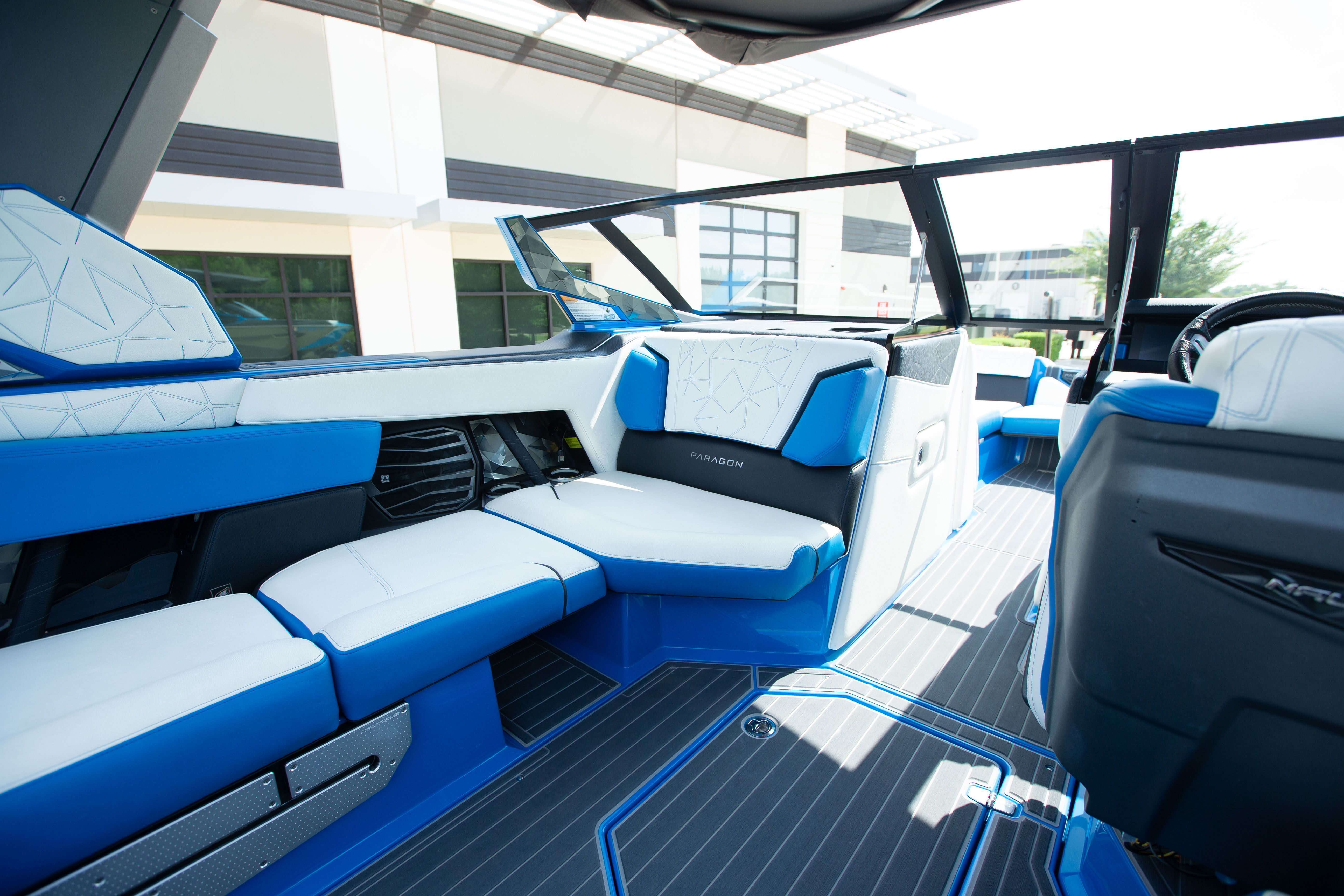 The interior of a luxury boat with blue and white seating.