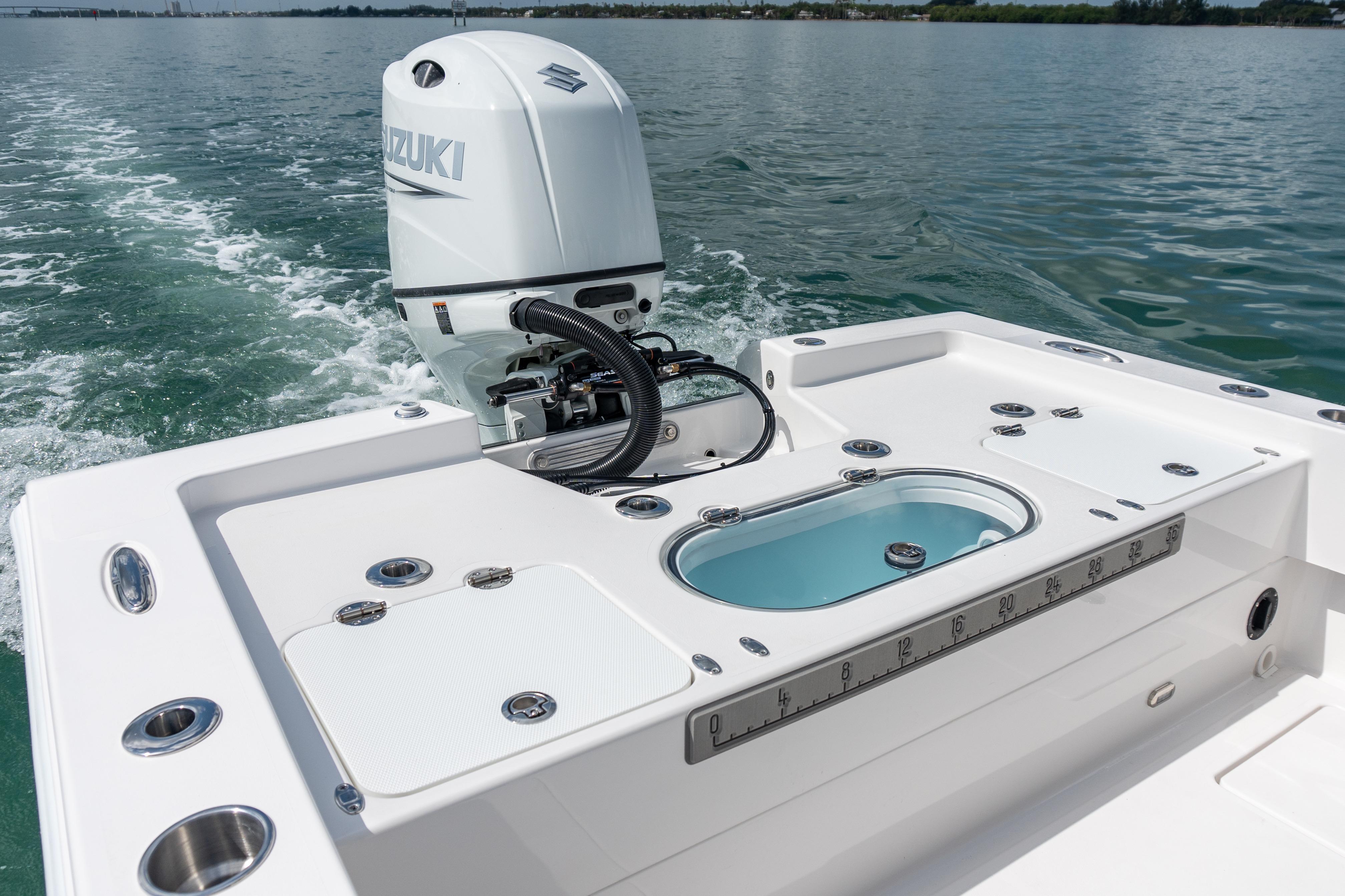 2026 Twin Vee 22 BayCat boat with Suzuki outboard motor on calm water.