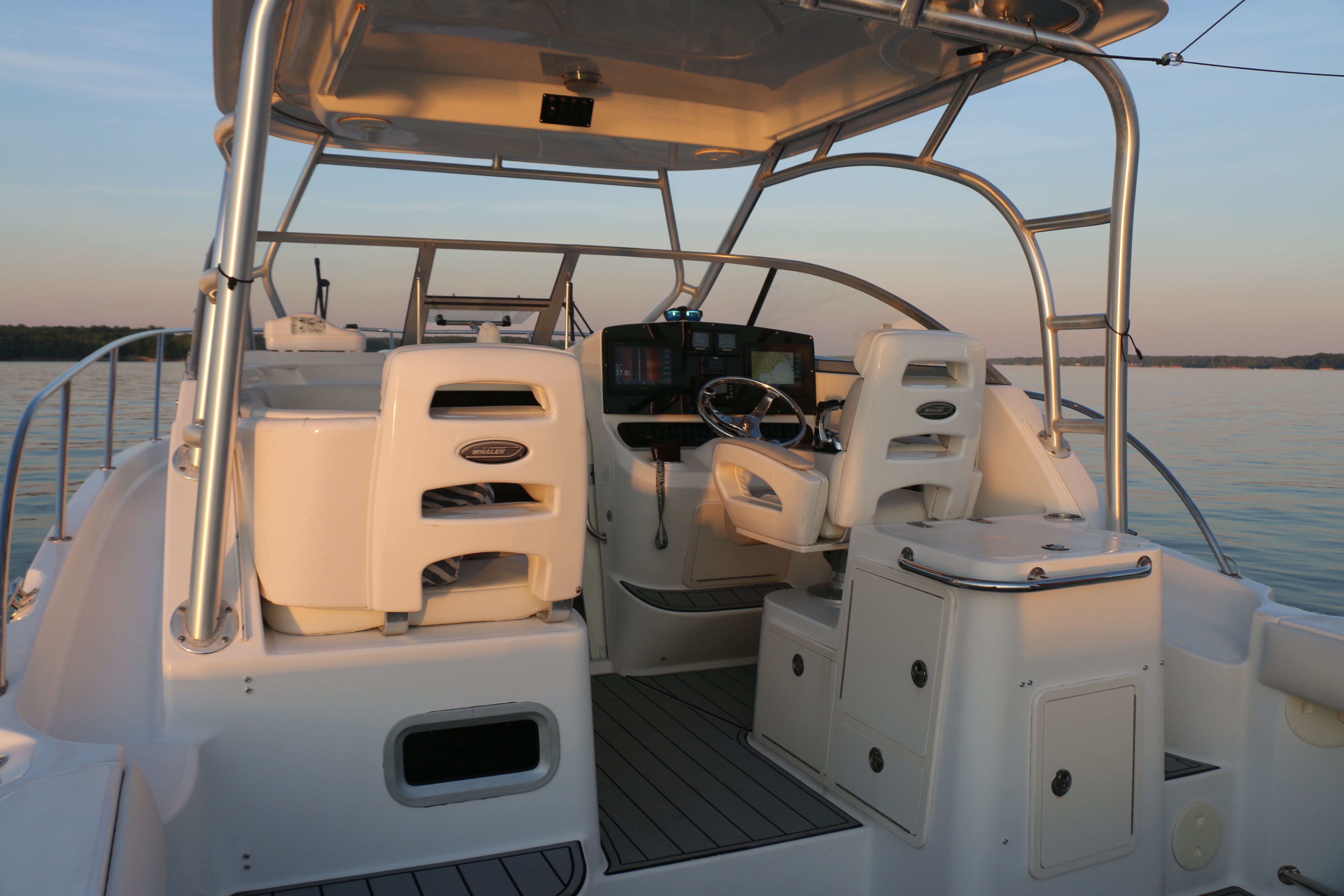 The image shows the cockpit of a 2006 Boston Whaler 305 Conquest on calm water.