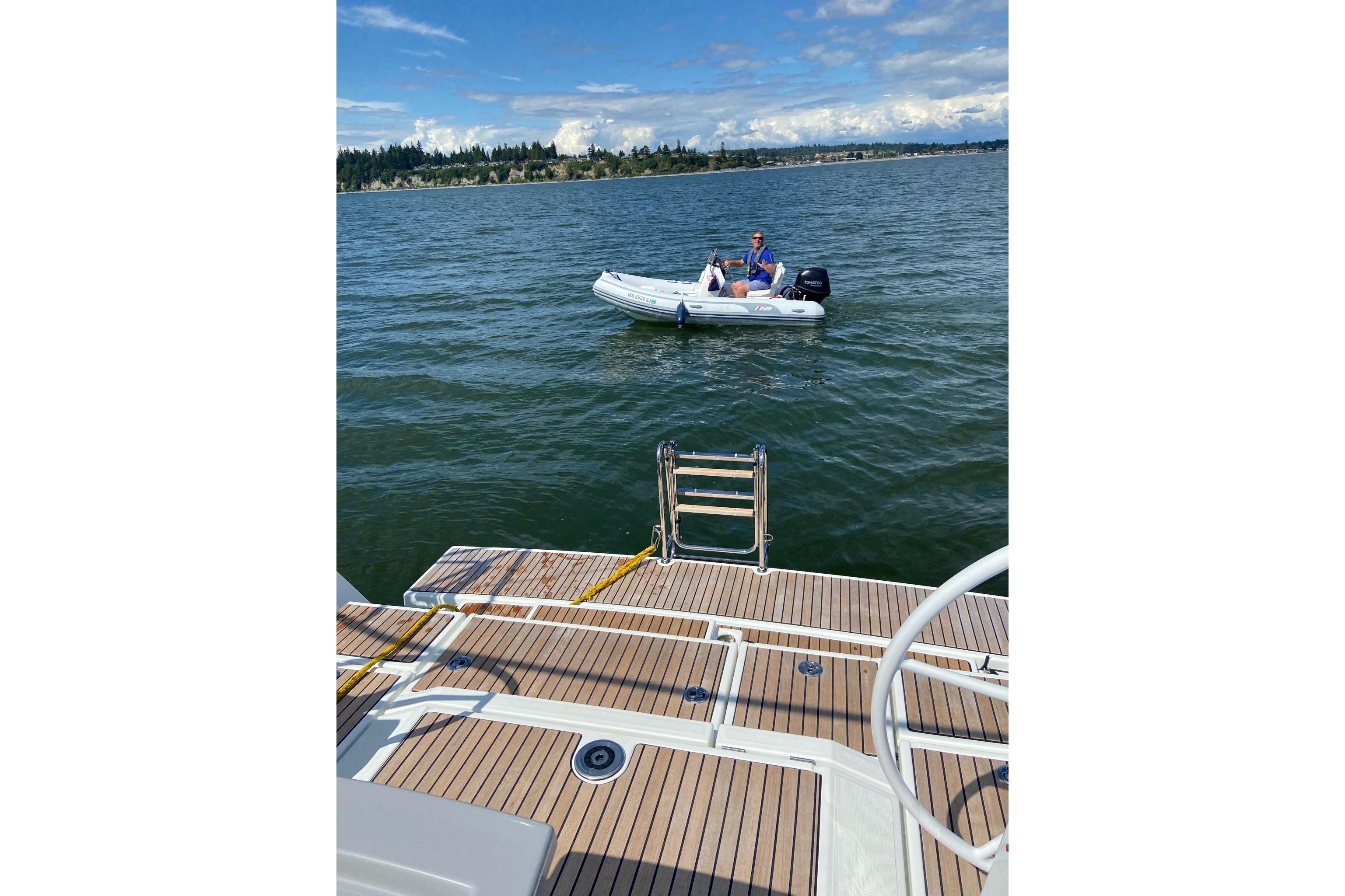 Beneteau Oceanis 45 yacht deck with person in dinghy on water, 2018 model.