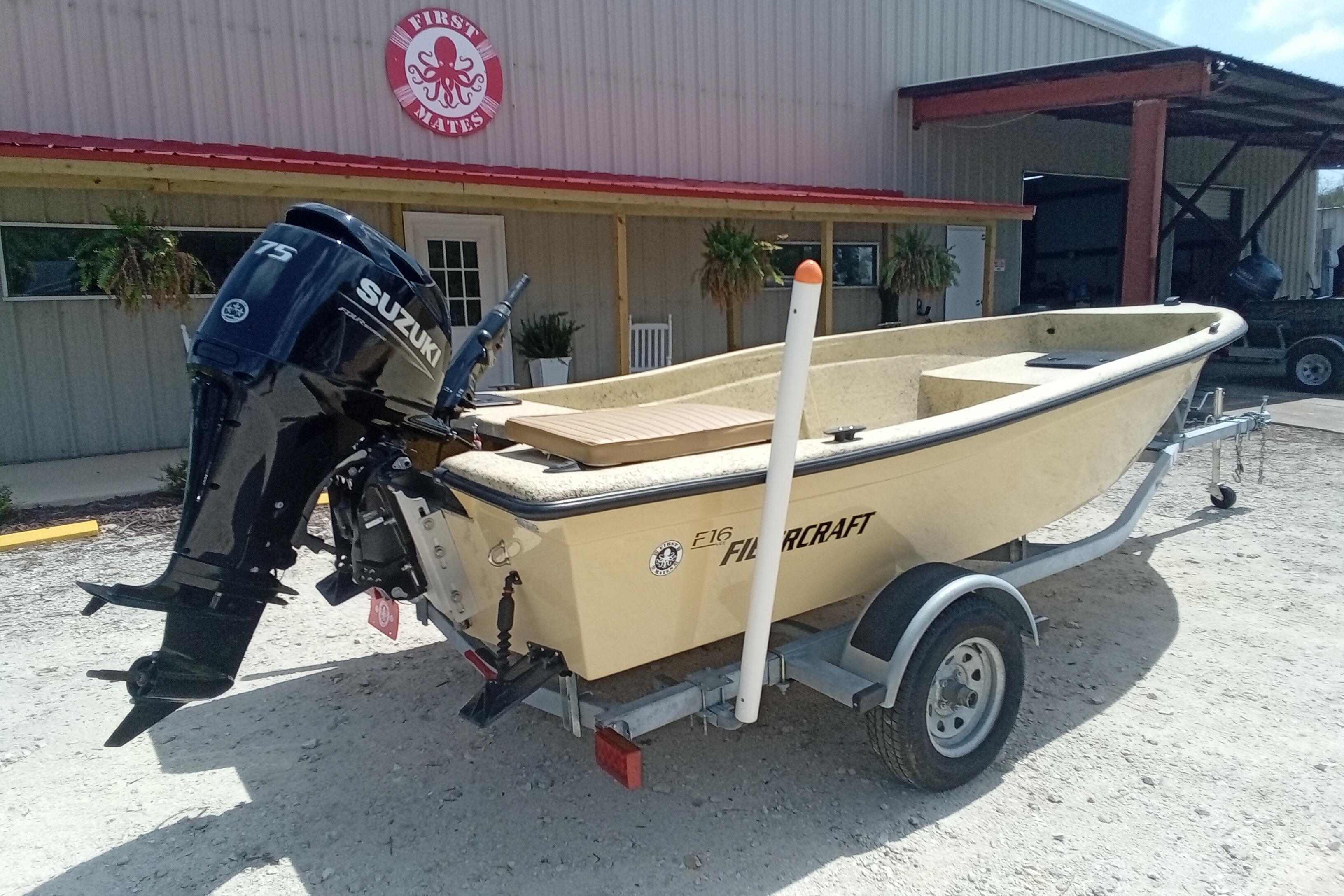 2025 Fibercraft F16 boat with Suzuki engine on trailer outside a building.