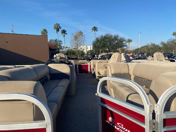2020 Sun Tracker Party Barge 24 DLX pontoon boat with beige seating, parked outdoors.
