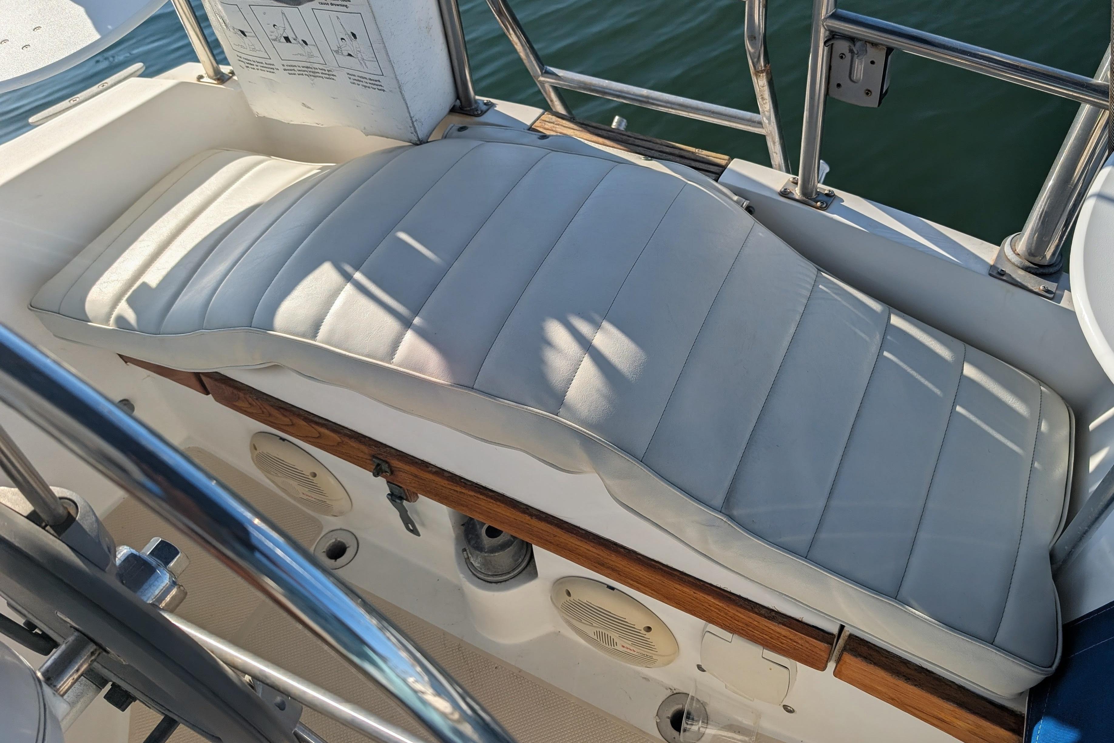 White cushioned seating on a 1989 Catalina 34 sailboat deck, with metal railings.