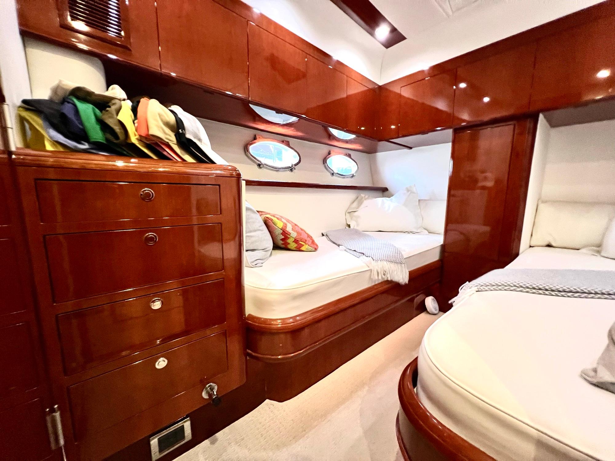 Luxurious cabin interior of 1999 Fairline Squadron 65 yacht with wooden cabinetry and twin beds.