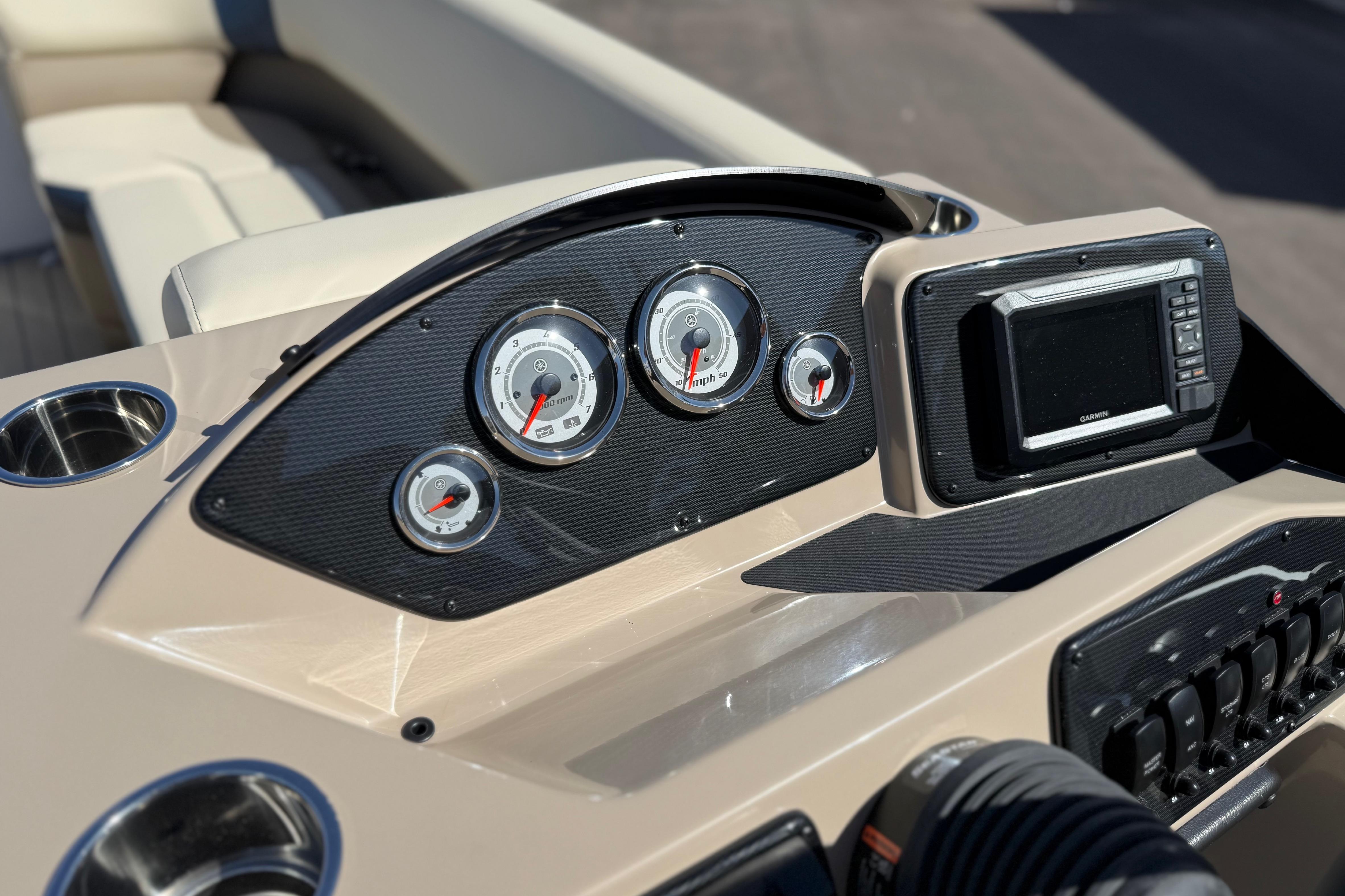 Dashboard of 2026 SunCatcher Select 322SL boat with gauges and navigation system.