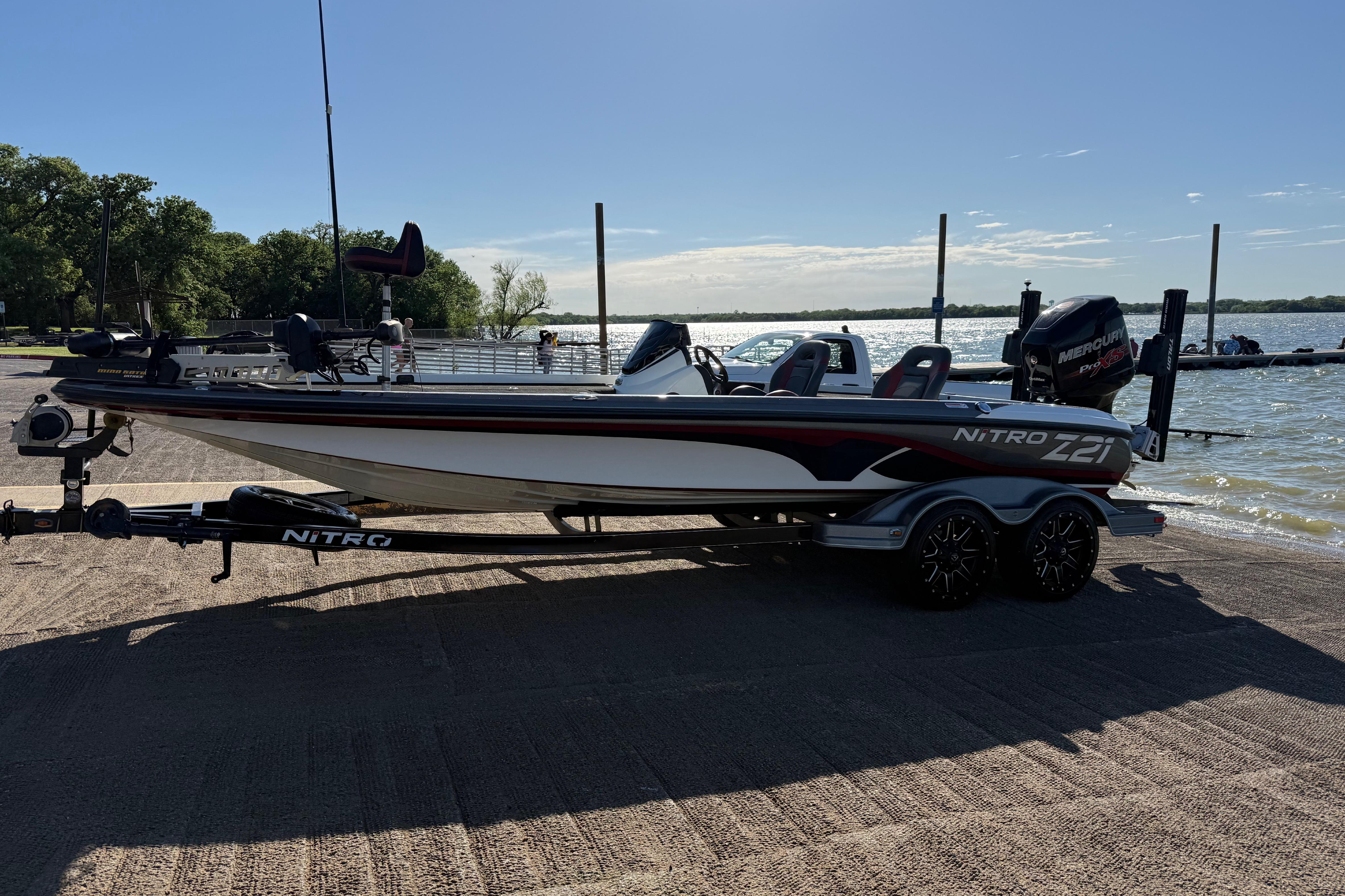 2016 Nitro Z21 boat on trailer by a lakeside, ready for fishing adventure.