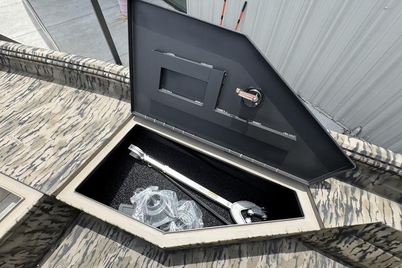 Open storage compartment on 2027 Excel 230 Bay Pro Elite boat, showing equipment inside.