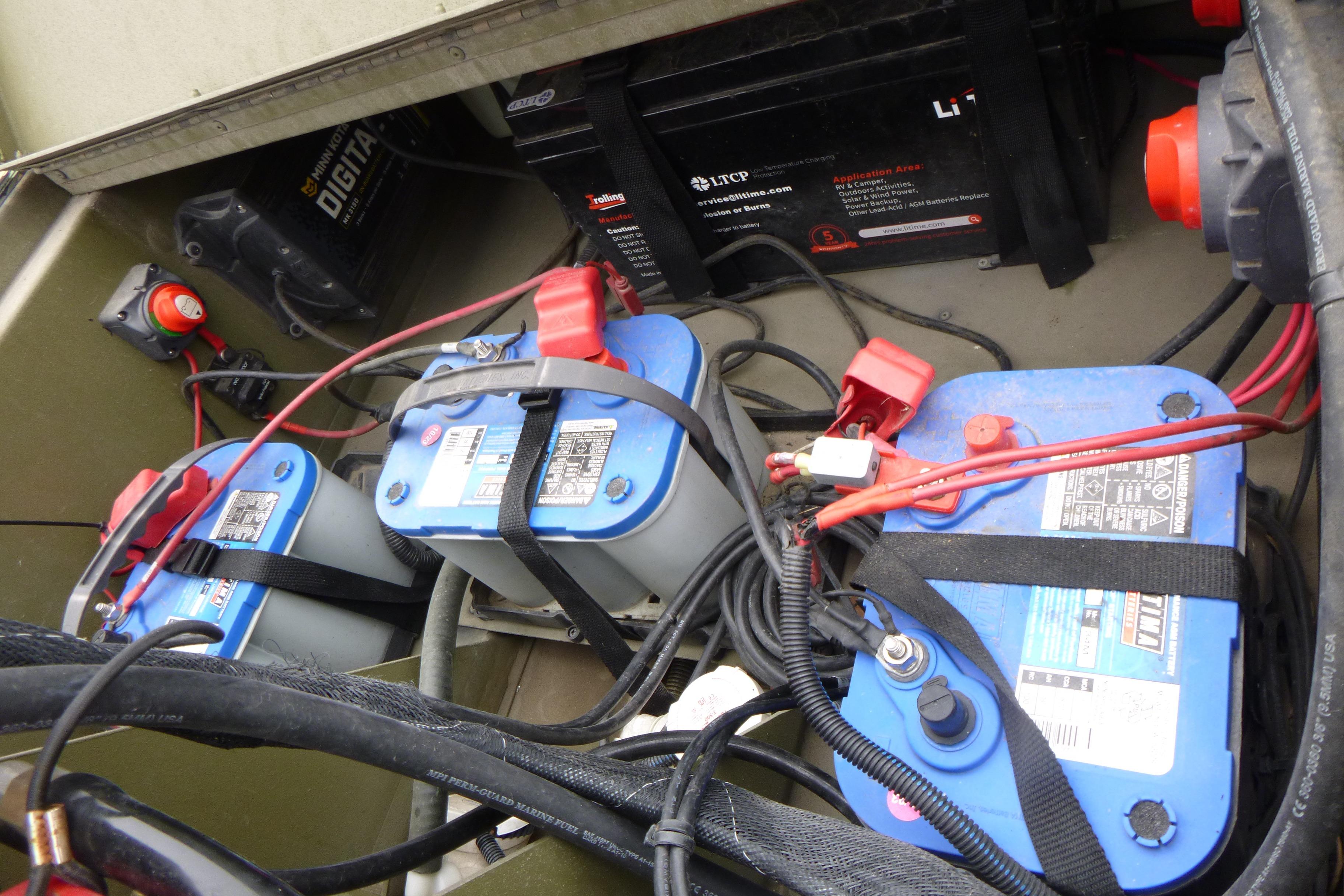 2024 Lowe Roughneck 2070 boat battery compartment with multiple batteries and wiring.