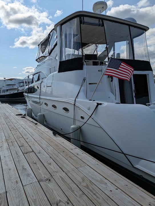 2005 Meridian 459 Motoryacht docked with American flag, under a partly cloudy sky.