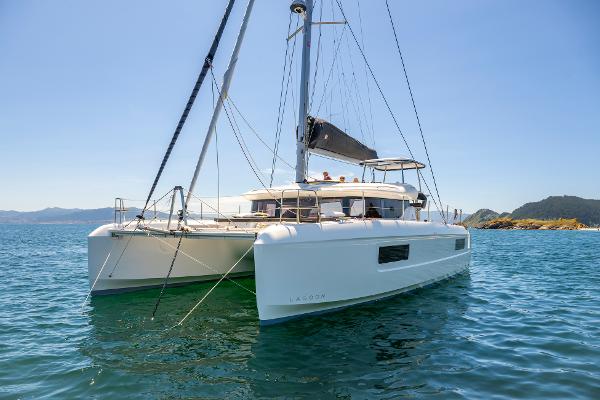 2025 Lagoon 43 catamaran sailing on clear blue waters under a sunny sky.