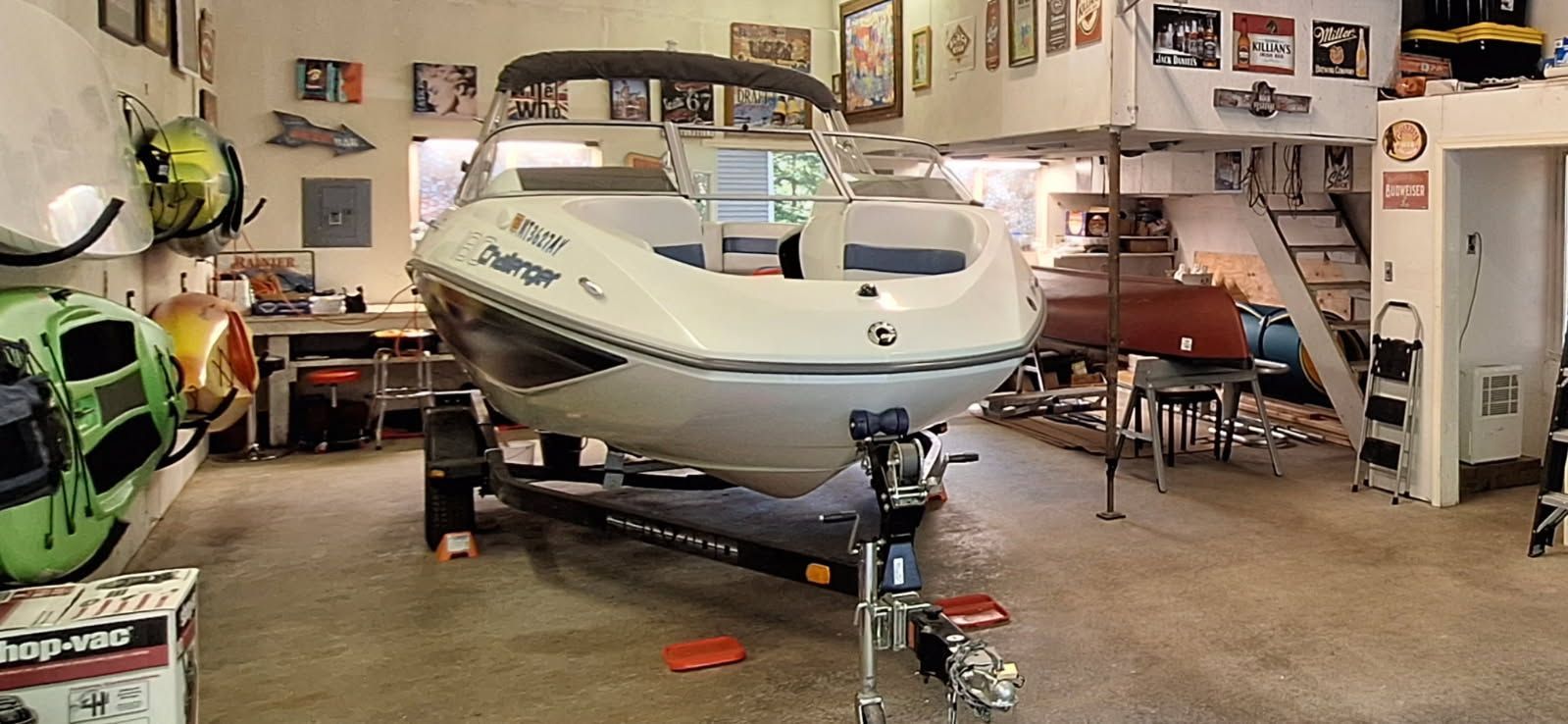 2007 Sea-Doo 180 Challenger in a workshop, on a trailer, surrounded by tools and decorations.