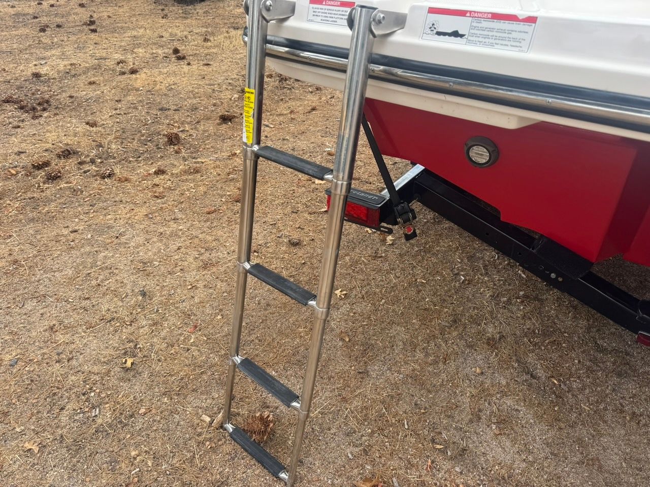 A swim ladder is attached to the stern of a boat, which is on dry land.