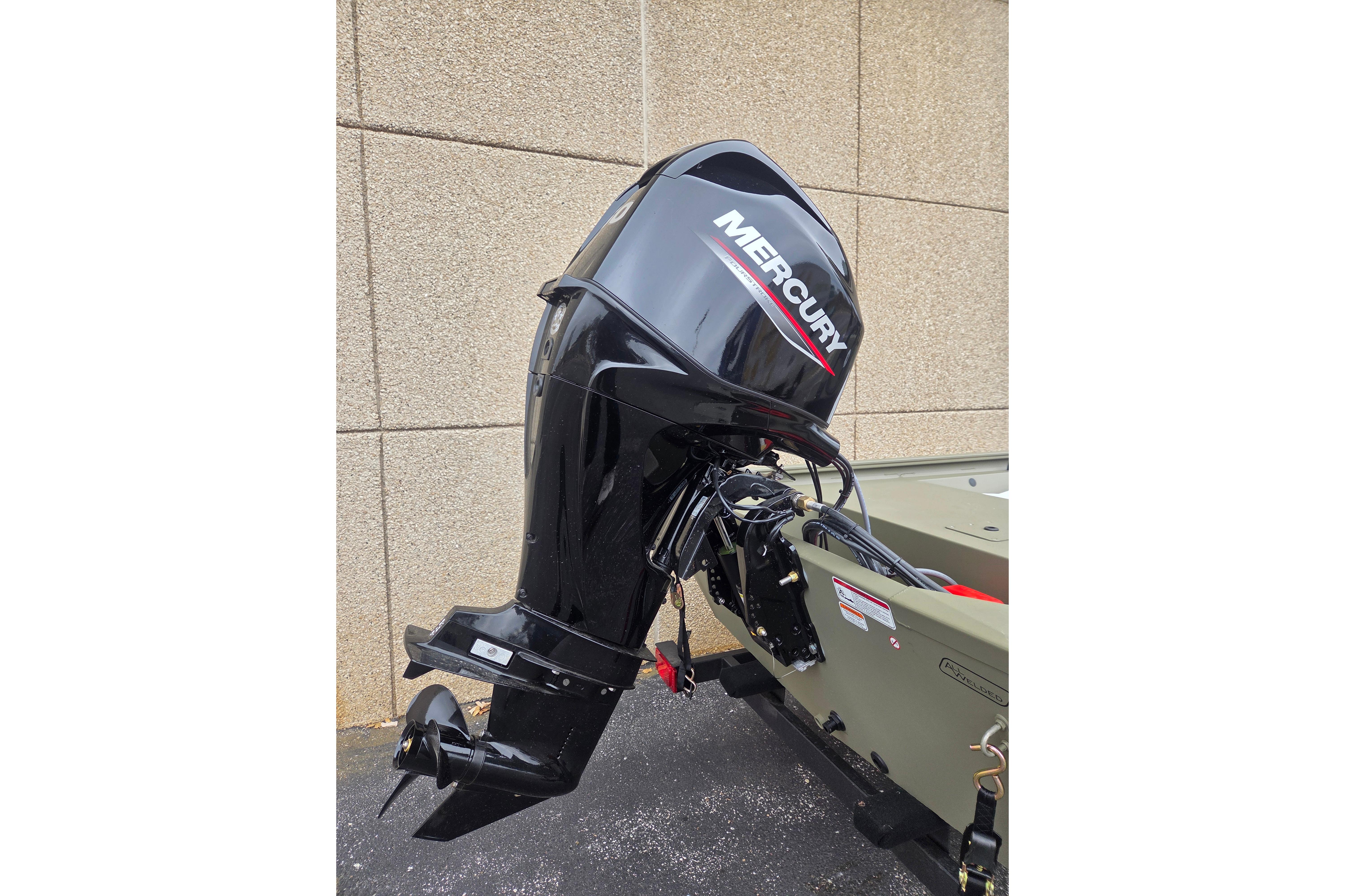 2026 Tracker Grizzly 1648 SC boat with Mercury outboard motor, parked outdoors.