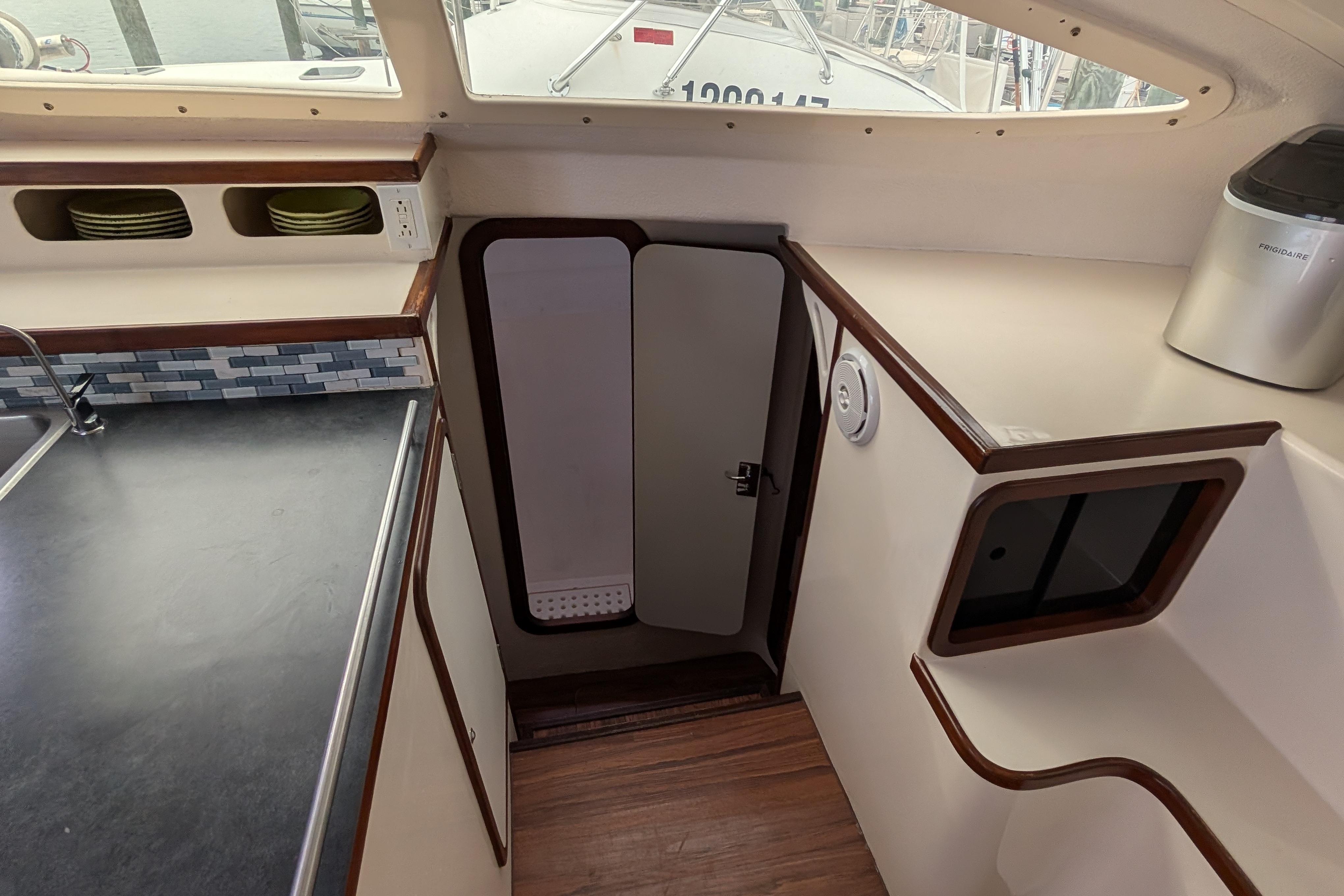 Interior of 1999 Island Spirit 37 yacht, featuring a compact kitchen area with modern amenities.