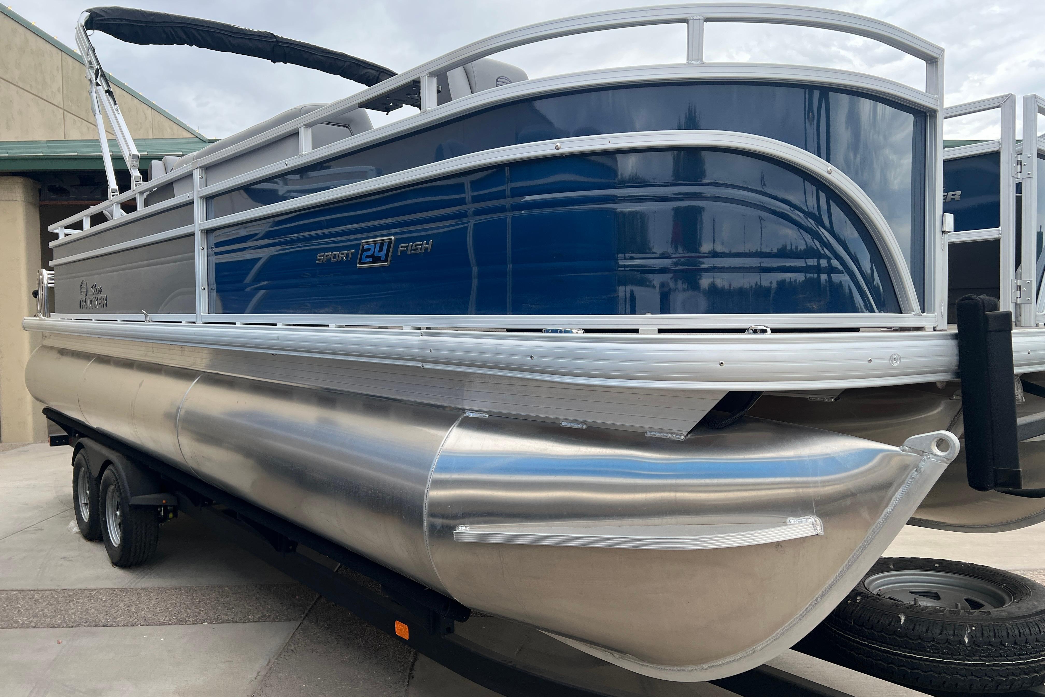 2026 Sun Tracker Sportfish 24 XP3 pontoon boat on trailer, side view.