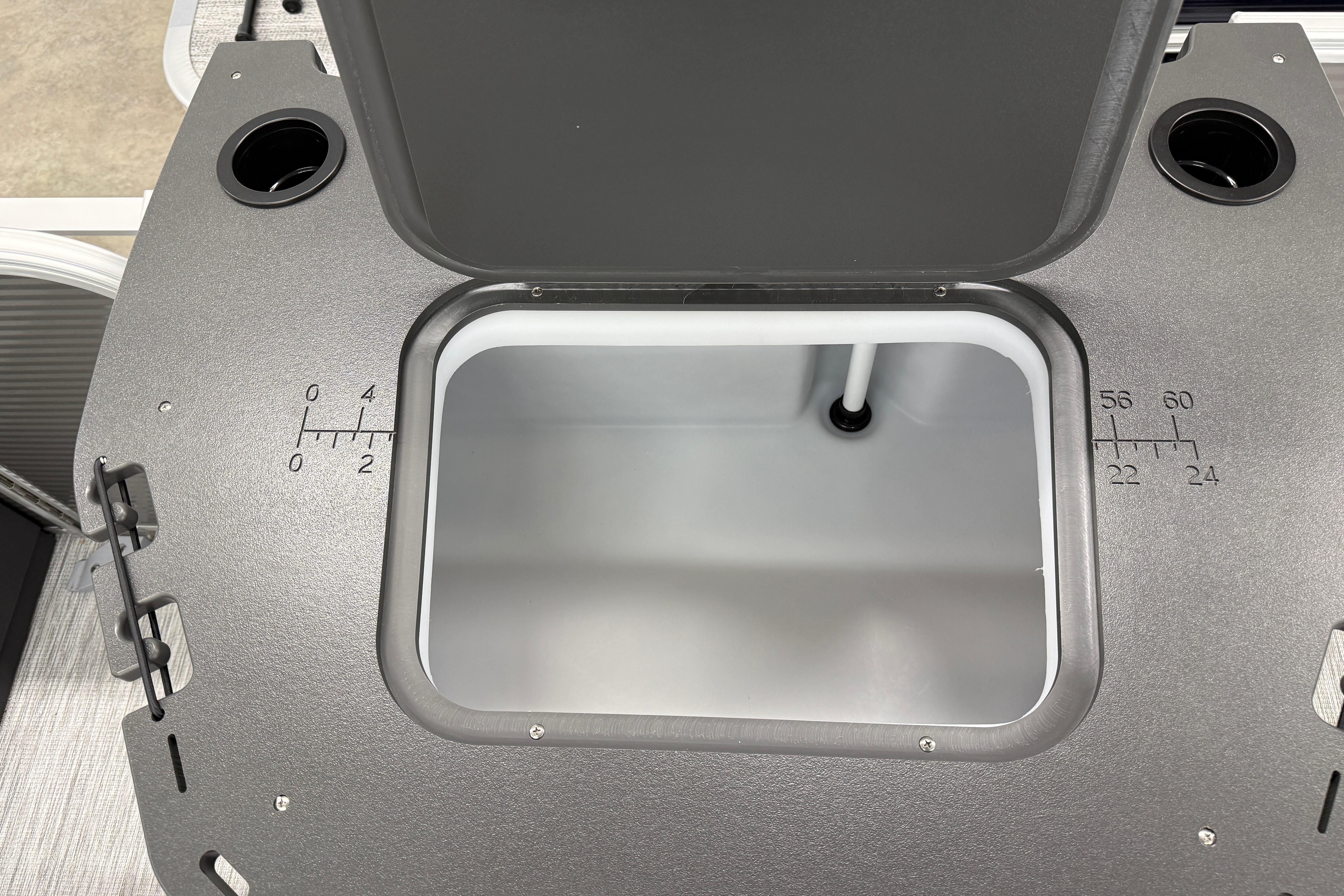 Open storage compartment on 2026 Bennington 20 SF boat, featuring measurement markings.