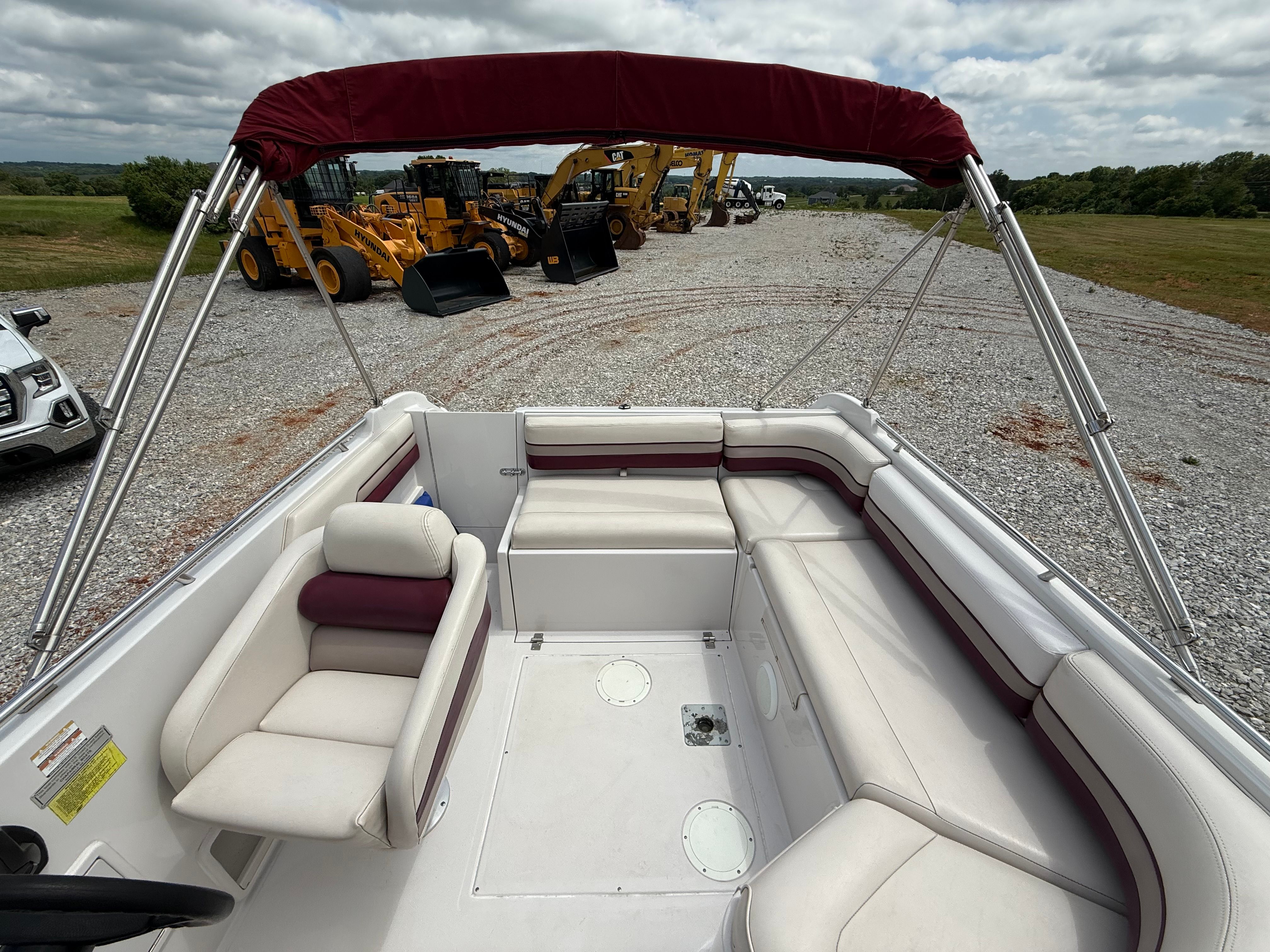 The image shows the cockpit of a Chaparral Sunesta 220 boat with red and white seating.