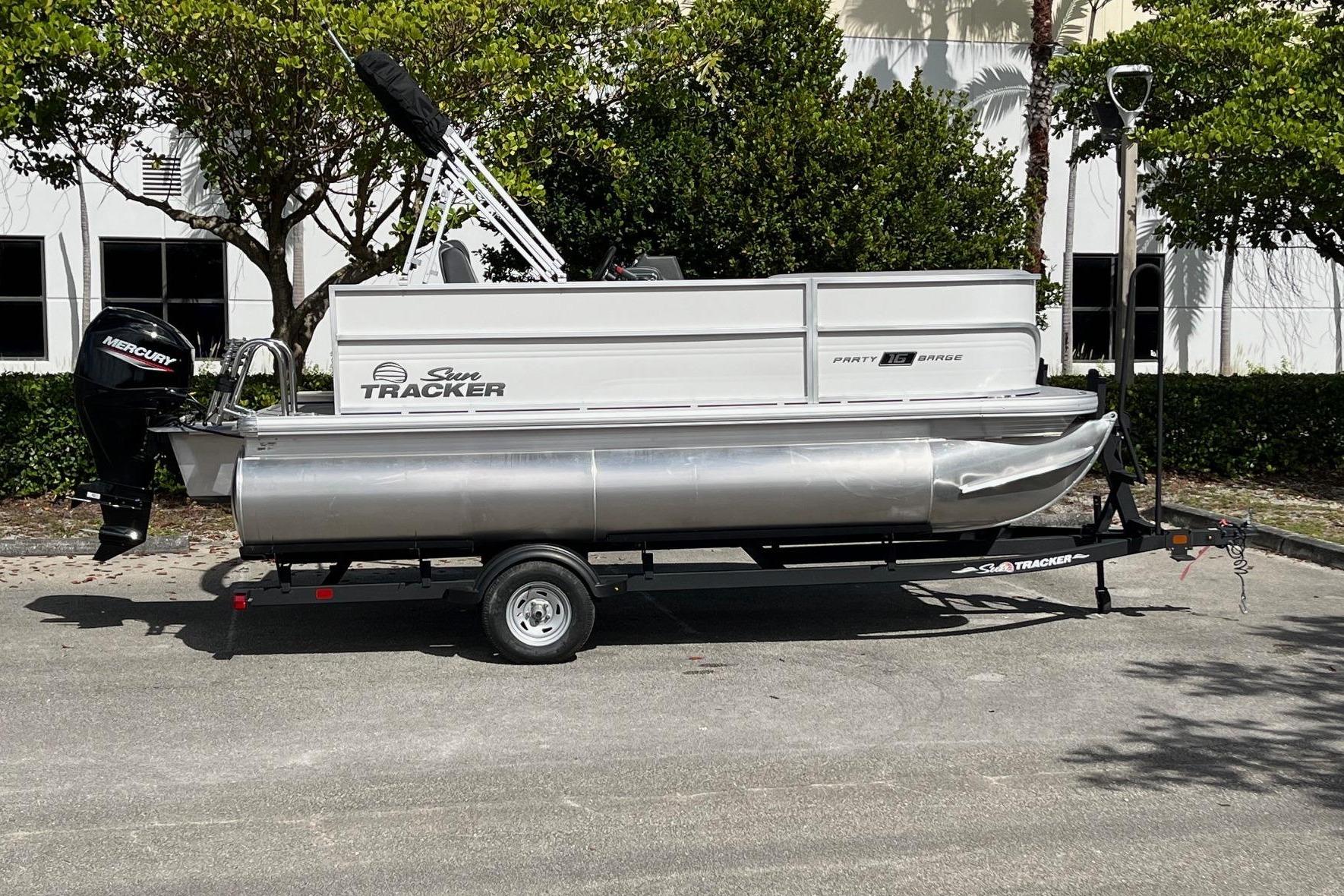 2026 Sun Tracker Party Barge 16 DLX pontoon boat on trailer, parked outdoors.
