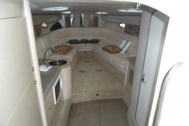 Interior of a 1999 Formula 400 Super Sport yacht with beige seating and kitchenette.