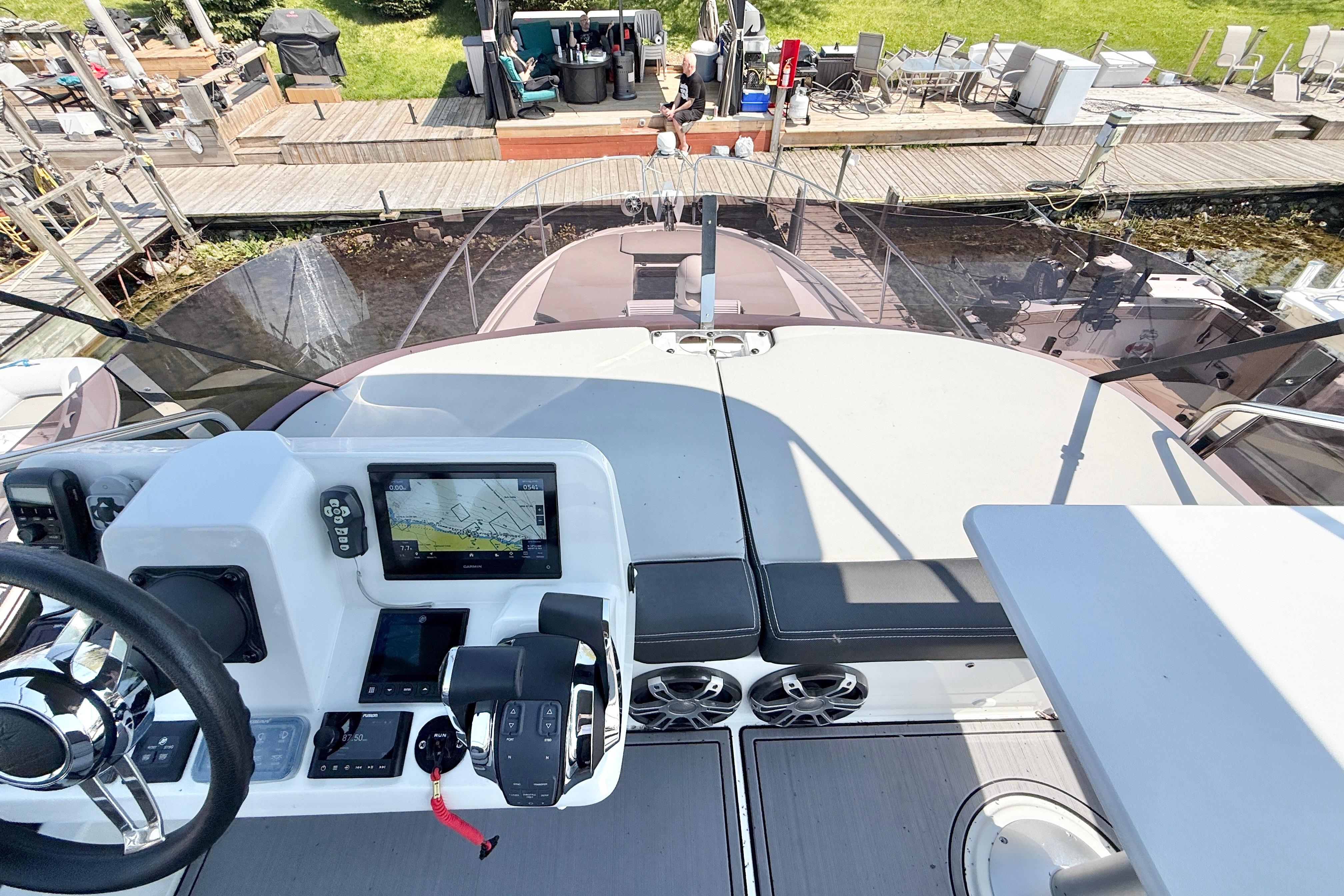 Flybridge view of 2022 Jeanneau NC 1095 Fly with navigation controls and seating area.