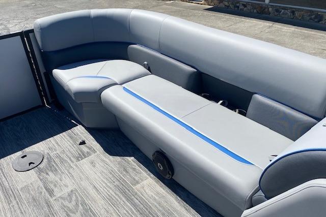 Gray upholstery on a pontoon boat with blue accents, set on a wooden deck.
