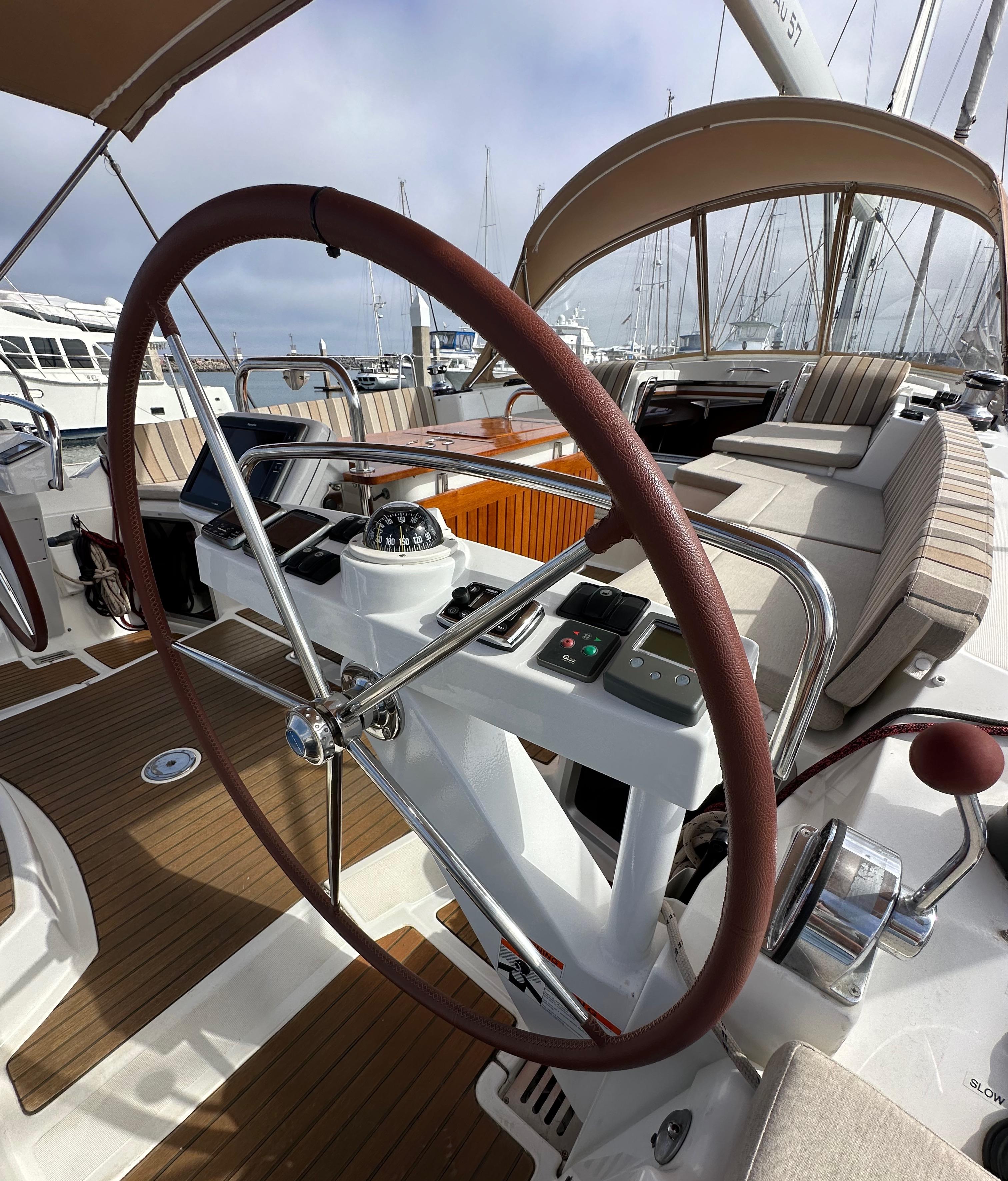 2014 Jeanneau 57 yacht cockpit with steering wheel and navigation controls.