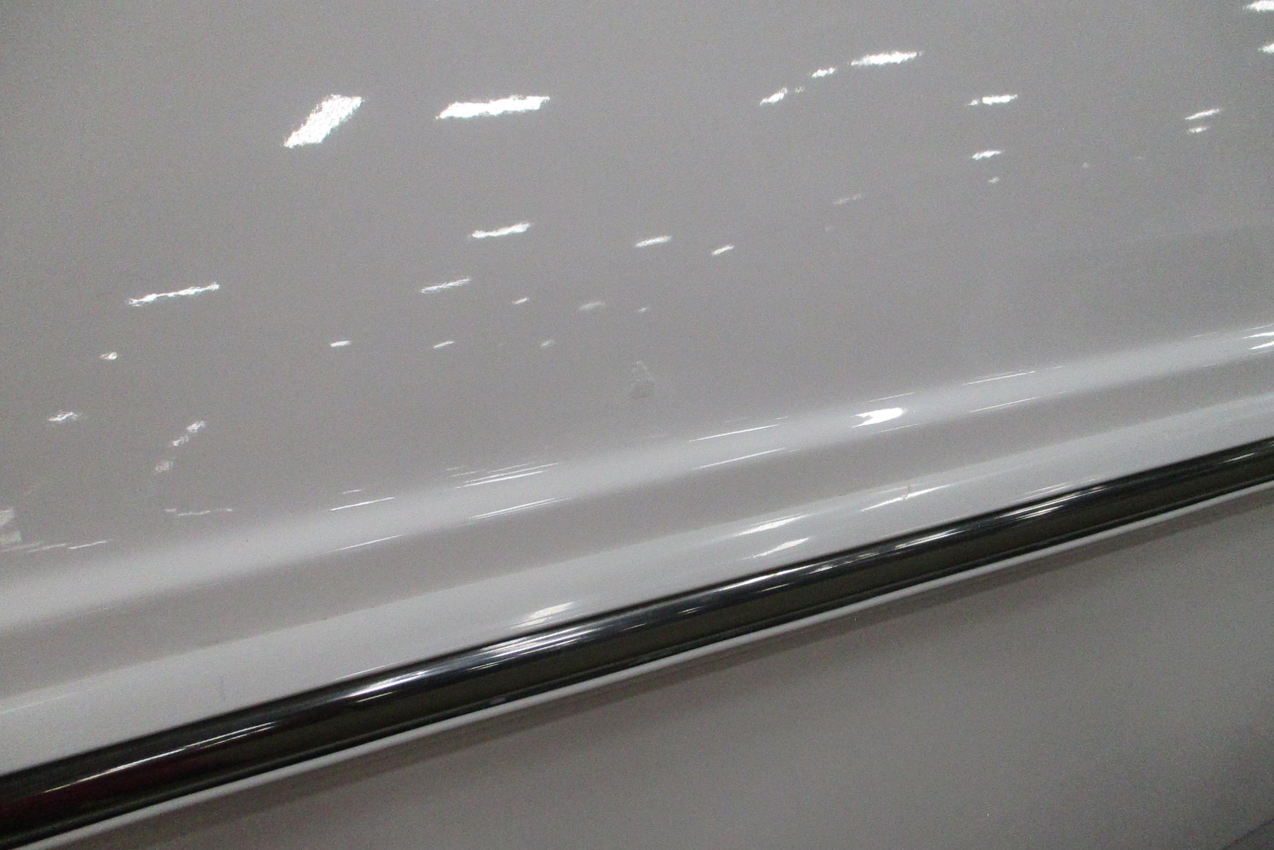 Close-up of 2025 Tahoe T18's sleek white exterior with chrome detailing.
