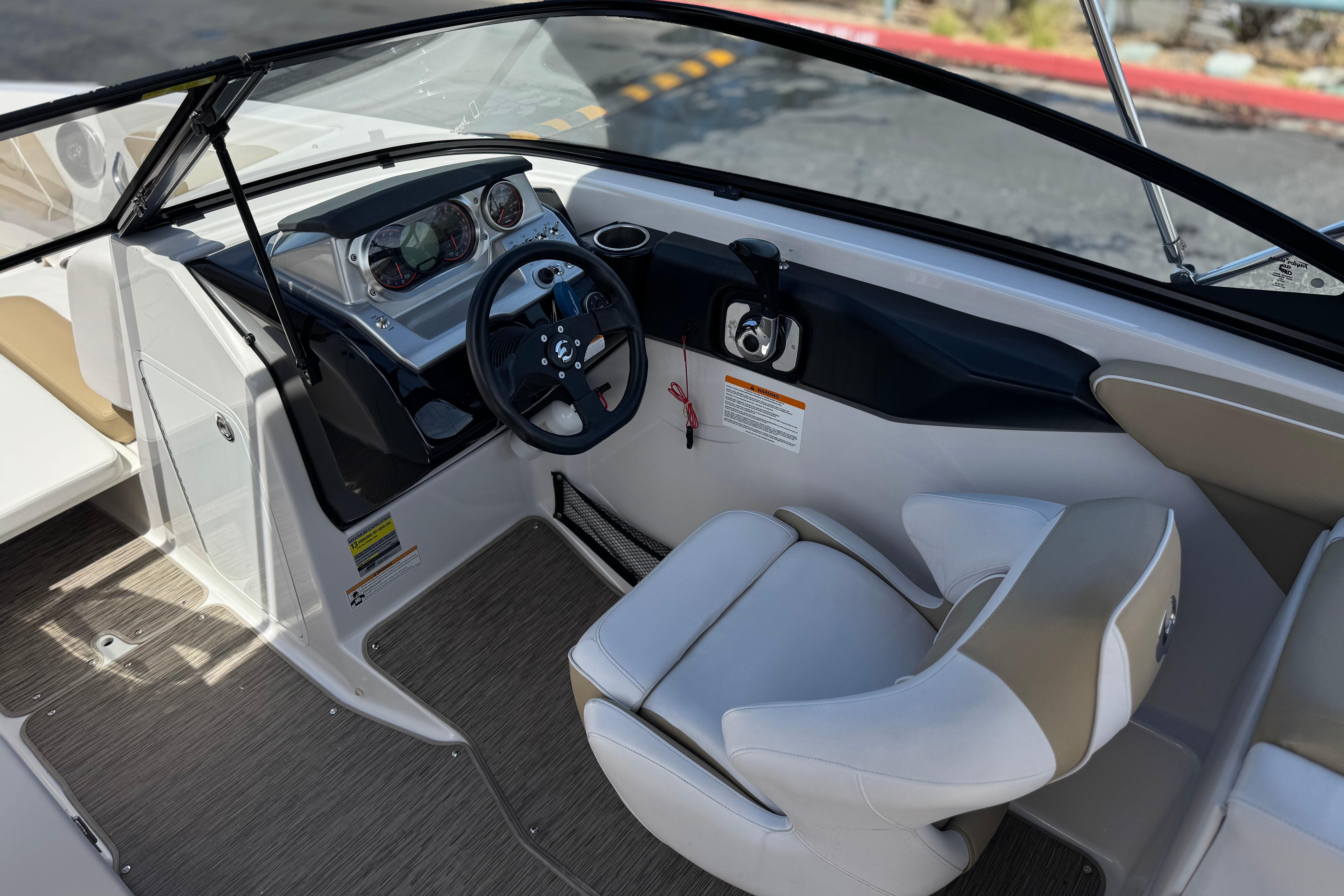 Interior view of 2017 Scarab 255 H.O. Platinum boat cockpit with steering wheel and seating.