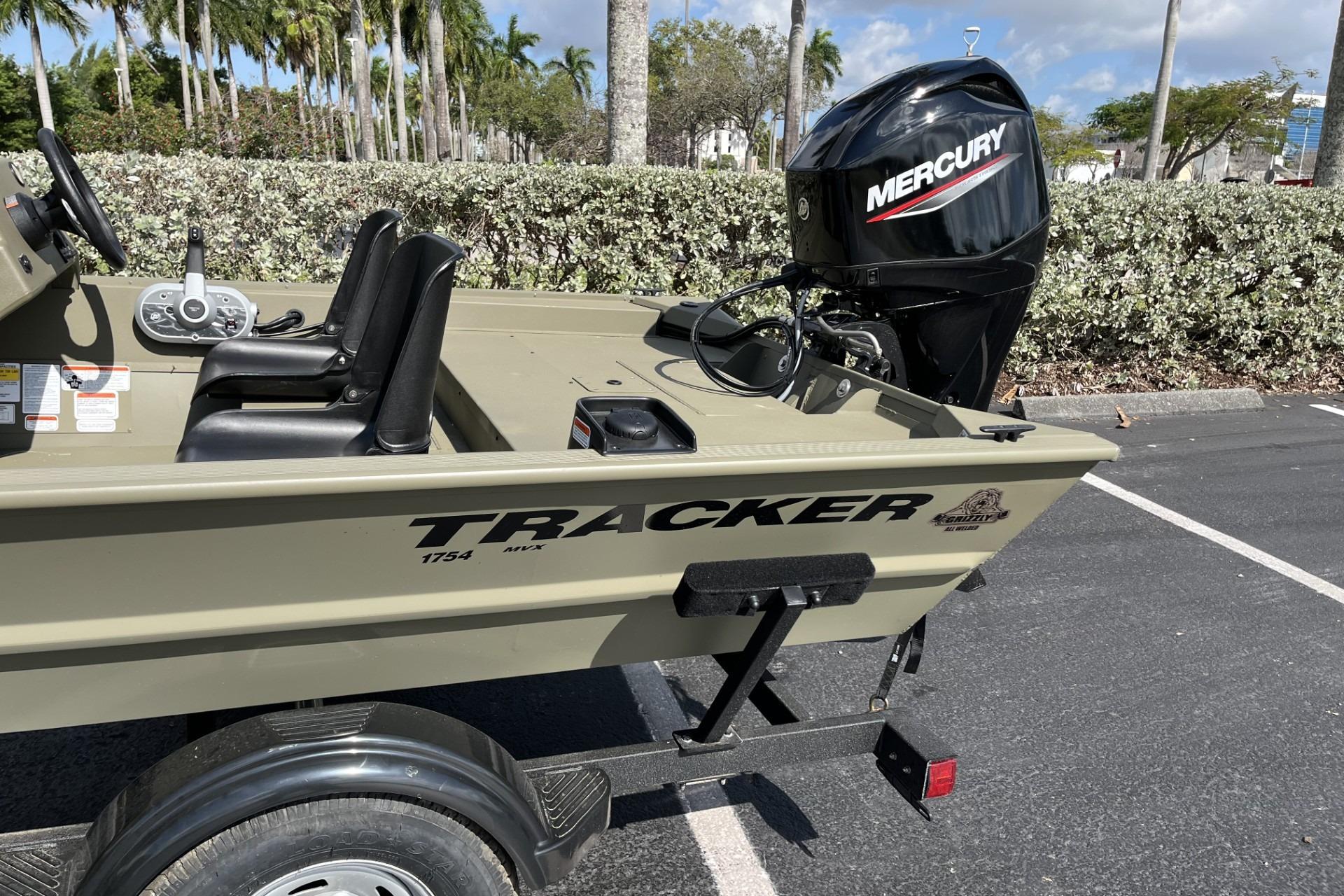 2026 Tracker Grizzly 1754 SC boat with Mercury engine in parking lot.