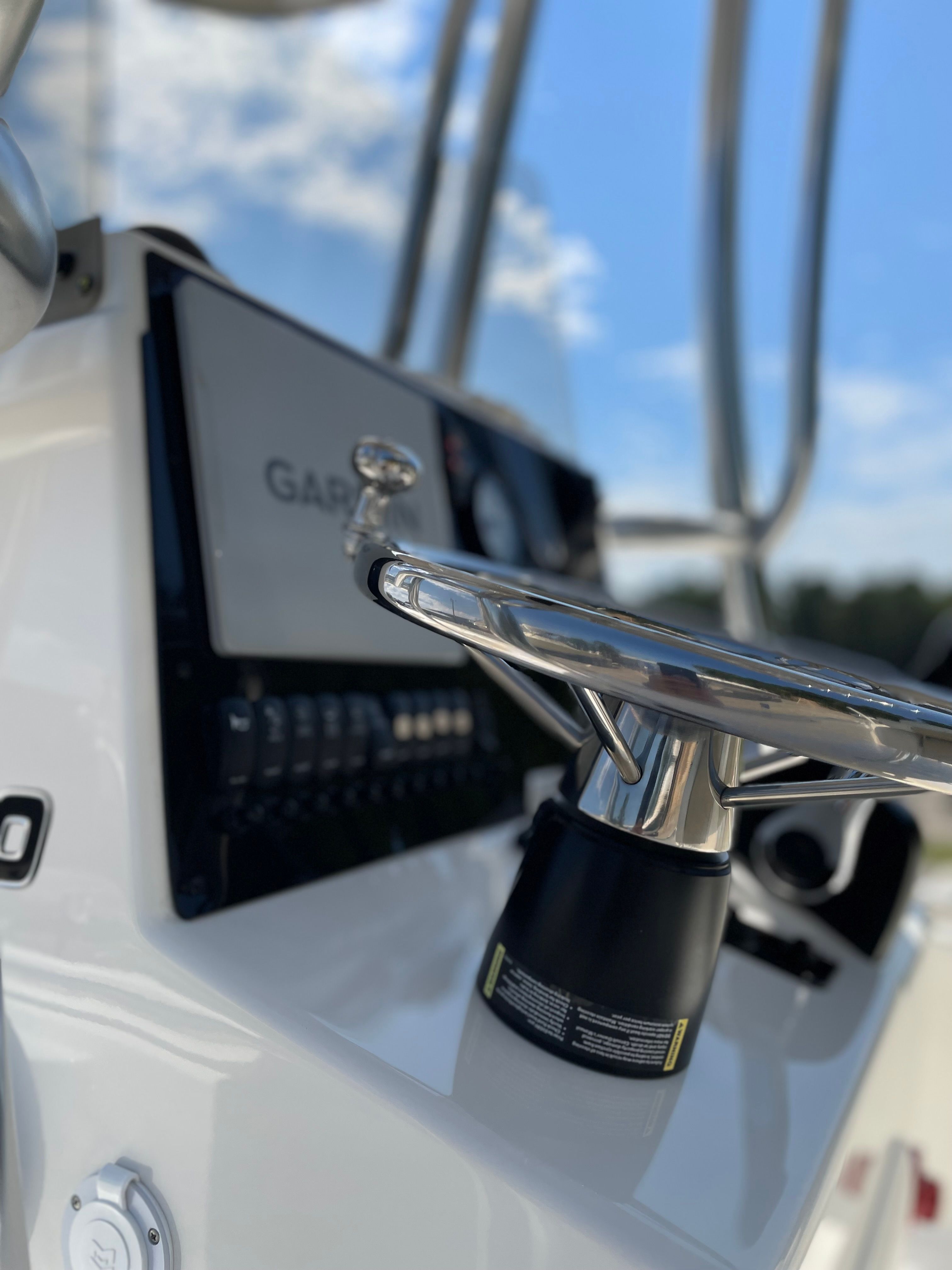 Close-up of a Bulls Bay 2400 boat helm with shiny steering wheel and electronics.