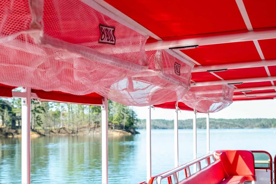 2024 Aloha Pontoon 50' Water Taxi interior with red canopy and lake view.
