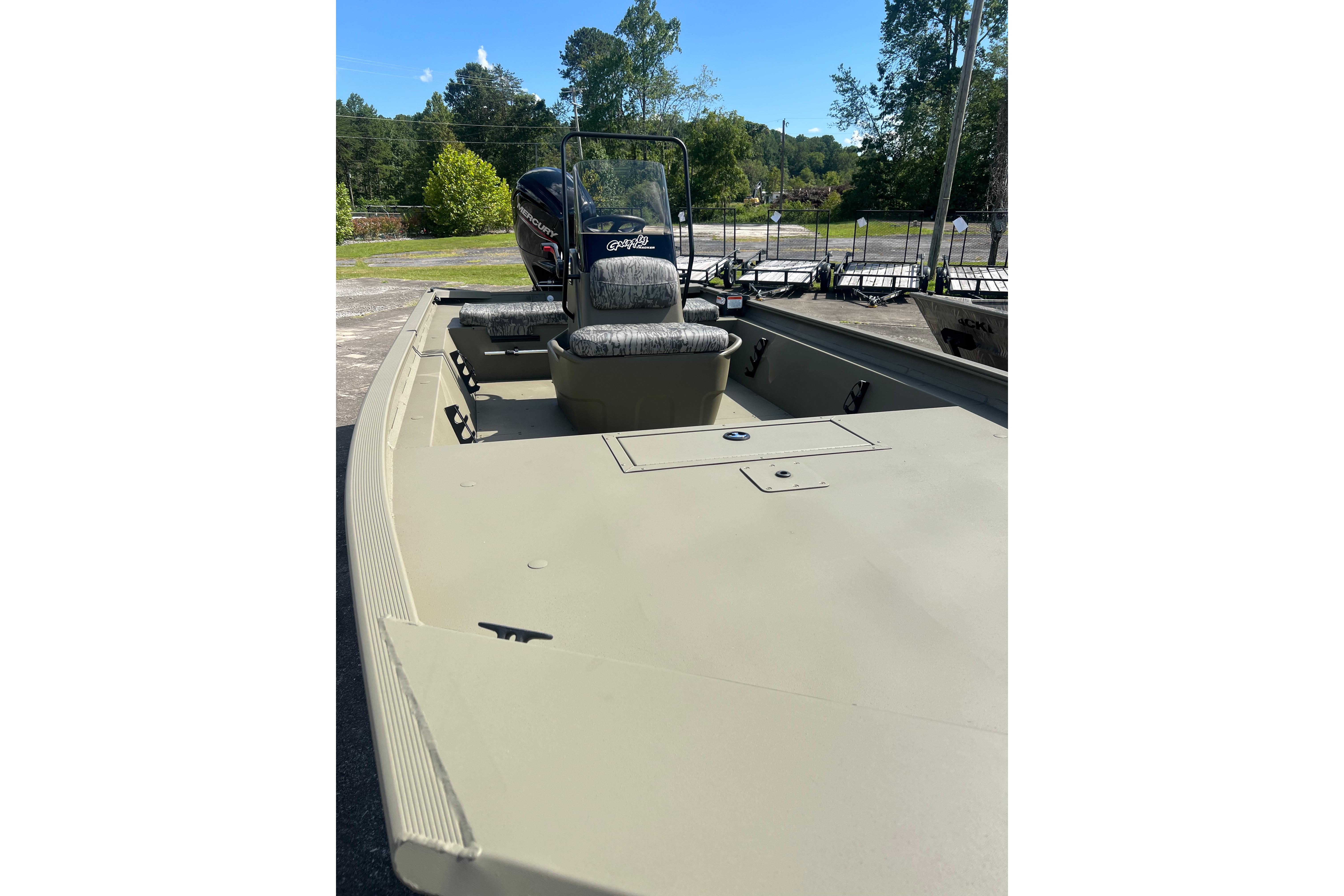2026 Tracker Grizzly 1860 CC boat with seating and console, outdoors on a sunny day.